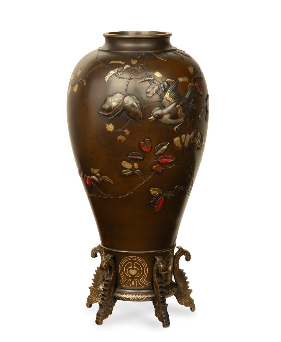 As part of our Japanese works of art collection we are delighted to offer this large and unusual form Meiji Period (1868-1912), bronze and mixed metal vase manufactured in the style of Suzuki Chokichi, the large bronze vase rests within a fitted