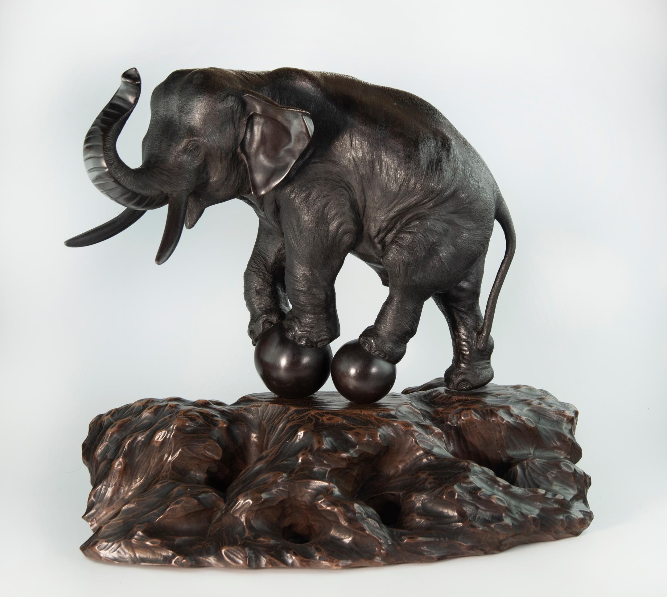 As part of our Japanese works of art collection we are delighted to offer this unusual Meiji Period 1868-1912 , study of a large elephant performing a balancing act upon two huge bronze spheres fitted with a bronze peg upon its original nicely