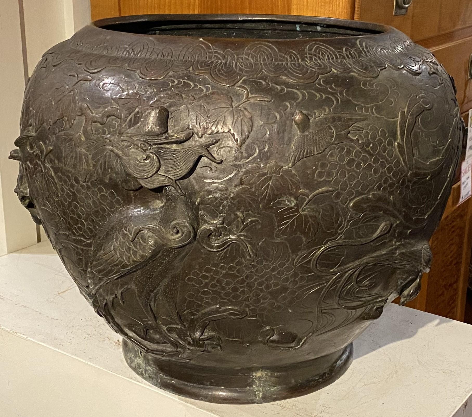 A fine large round Meiji bronze jardiniere with rooster decoration, accented with geometric shapes around the rim and foliate designs around the birds. Very good overall condition, with some evidence of verdigris, a minor hole in the base, and other