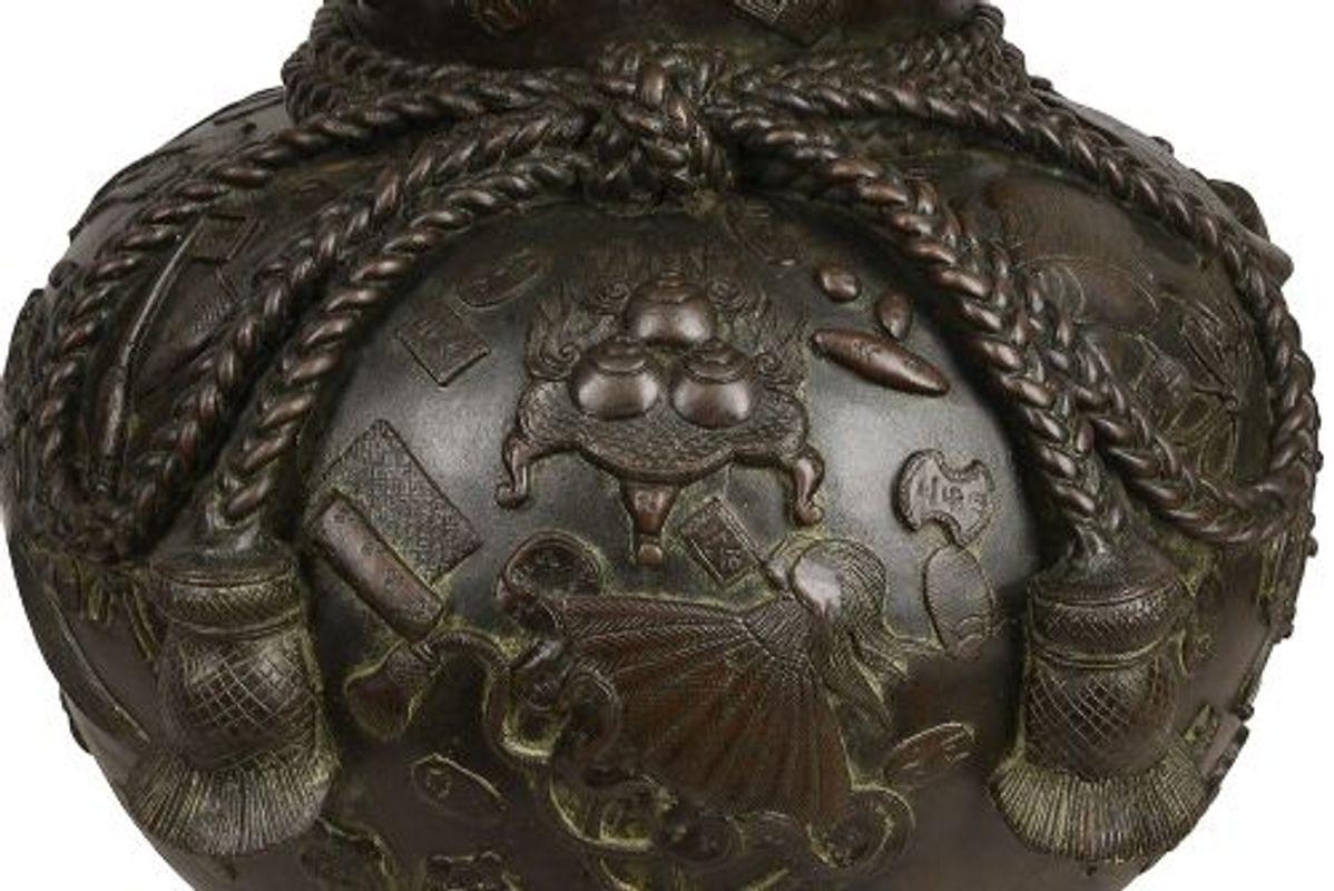 Eine große japanische Bronzevase in Form eines großen Schatzsacks, der am Hals mit einer Quastenschnur gebunden ist und in Relief mit verstreutem Bargeld, Schriftrollen, Musikinstrumenten und buddhistischen Schätzen gegossen ist, die Mündung hat
