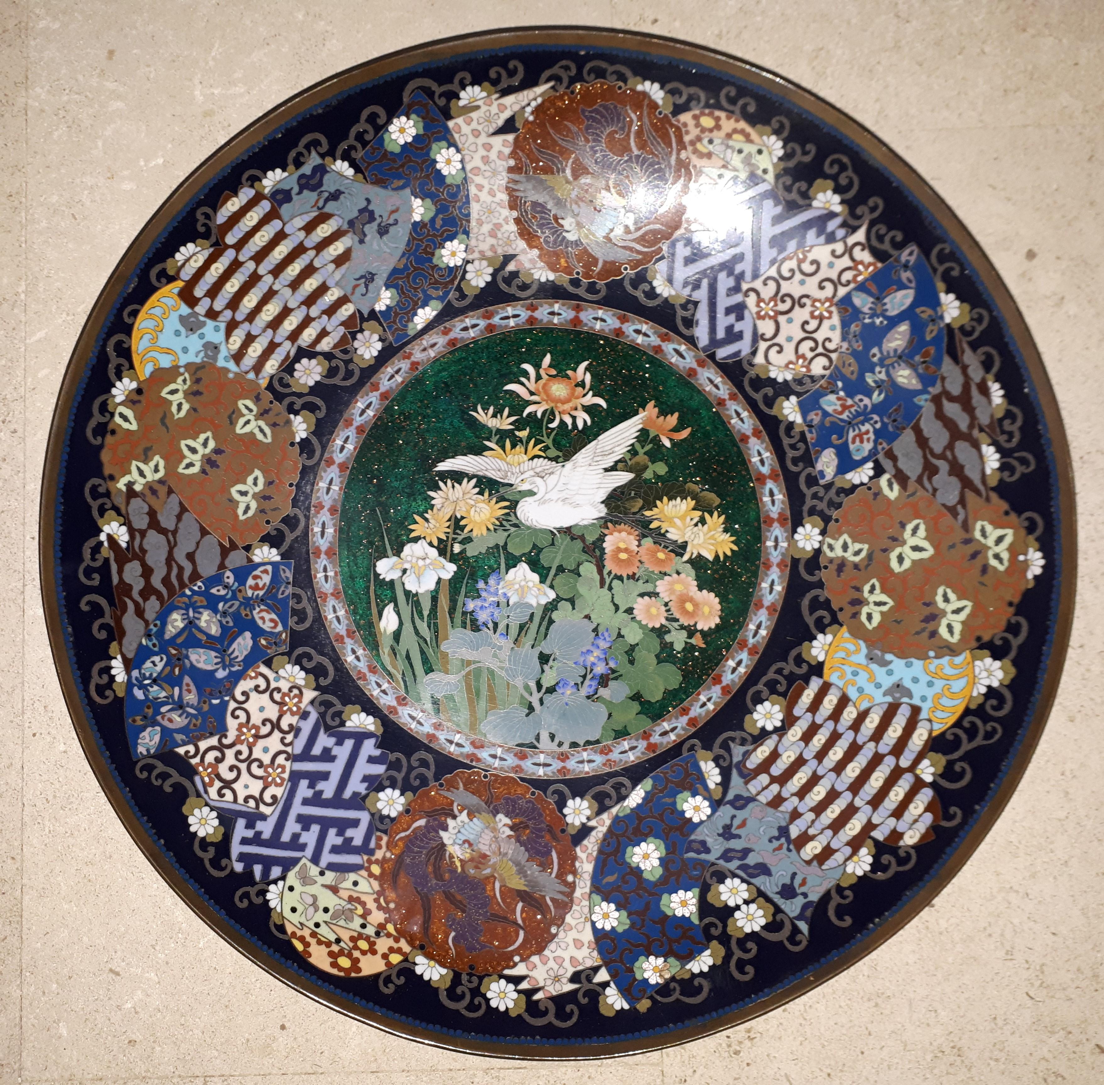 Bronze and cloisonné enamel dish very finely decorated with an egret in flight above various flowers on a background of copper inclusions and gold powder.
The wing decorated in particular with phoenixes and butterflies in flight on a background of