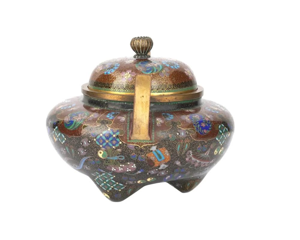 A fine quality Japanese cloisonne covered koro or incense burner, Meiji era, 1868 to 1912. The piece features cloisonne handles and cover. The exterior is decorated with various designs including floral motifs and takara-mono - precious things-