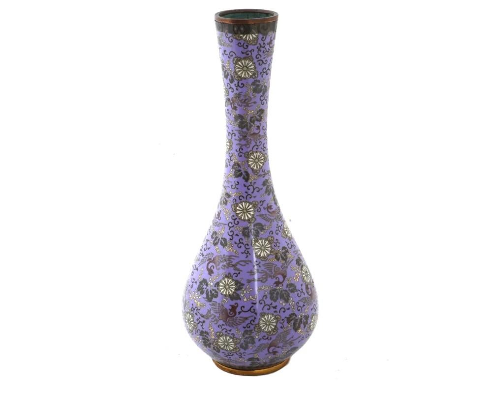 A rare large antique Japanese, Meiji era, enamel over copper vase. The vase has a globular shaped body and a long narrow neck with a fluted mouth. The exterior of the vase is enameled with a polychrome design depicting Phoenix birds and blossoming