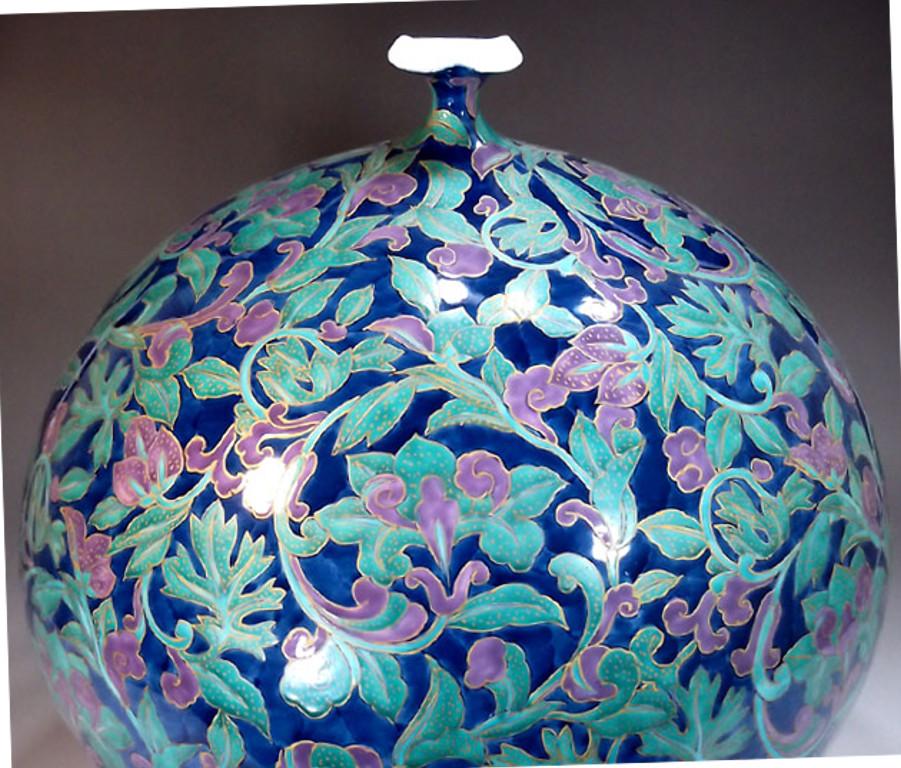 Unique contemporary large Japanese gilded and intricately hand painted decorative porcelain vase on an attractive ovoid shape in textured dark blue and flora pattern (Karakusa) with flowers and foliage in stunning green and purple, a signed