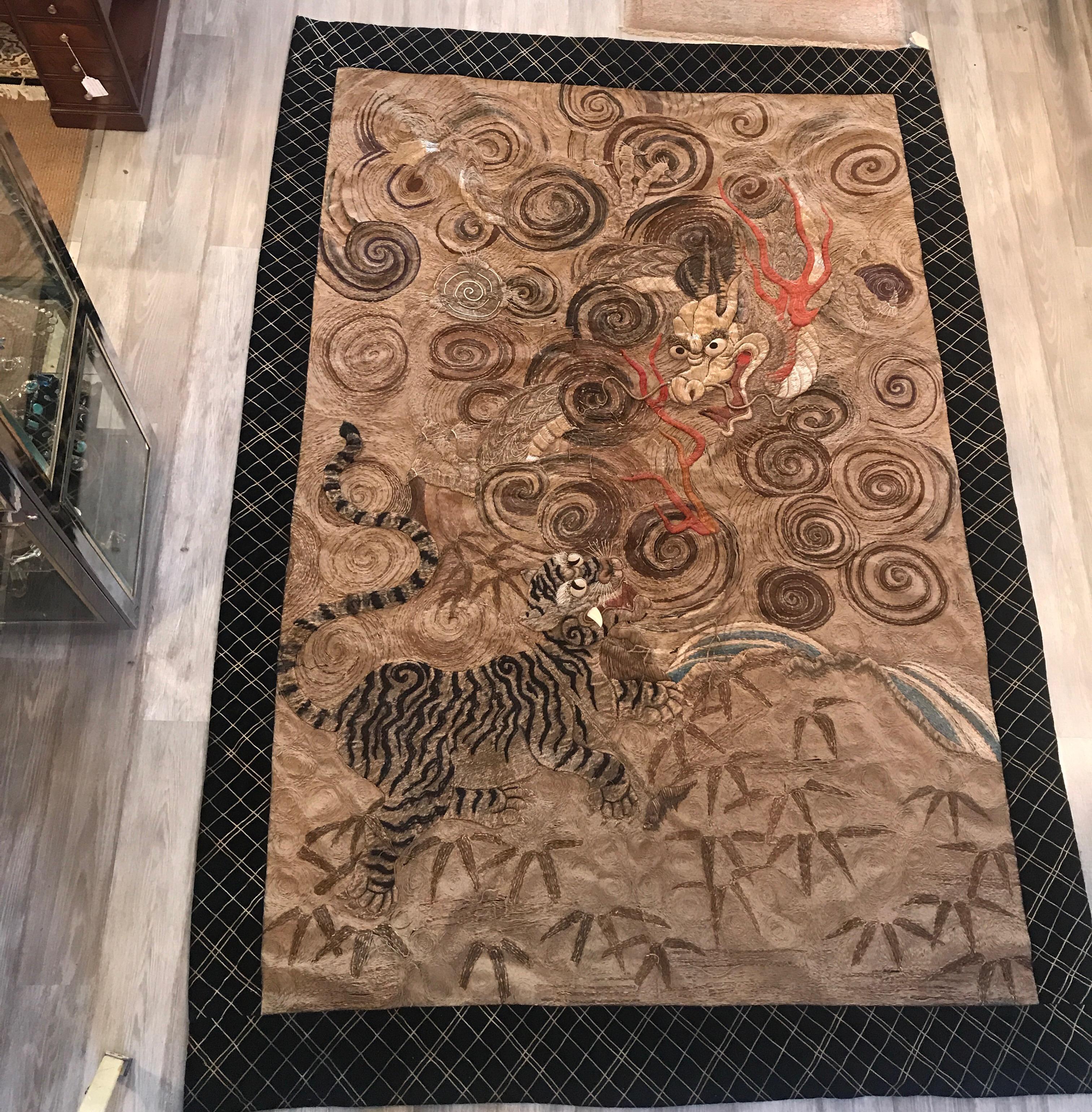 An impressive handmade Japanese needlework tapestry with velvet border. The intricate tapestry with dragon and tiger with the background totally filled with hand stitched and embroidered pattern. The edge with a later velvet border, Meiji Period,