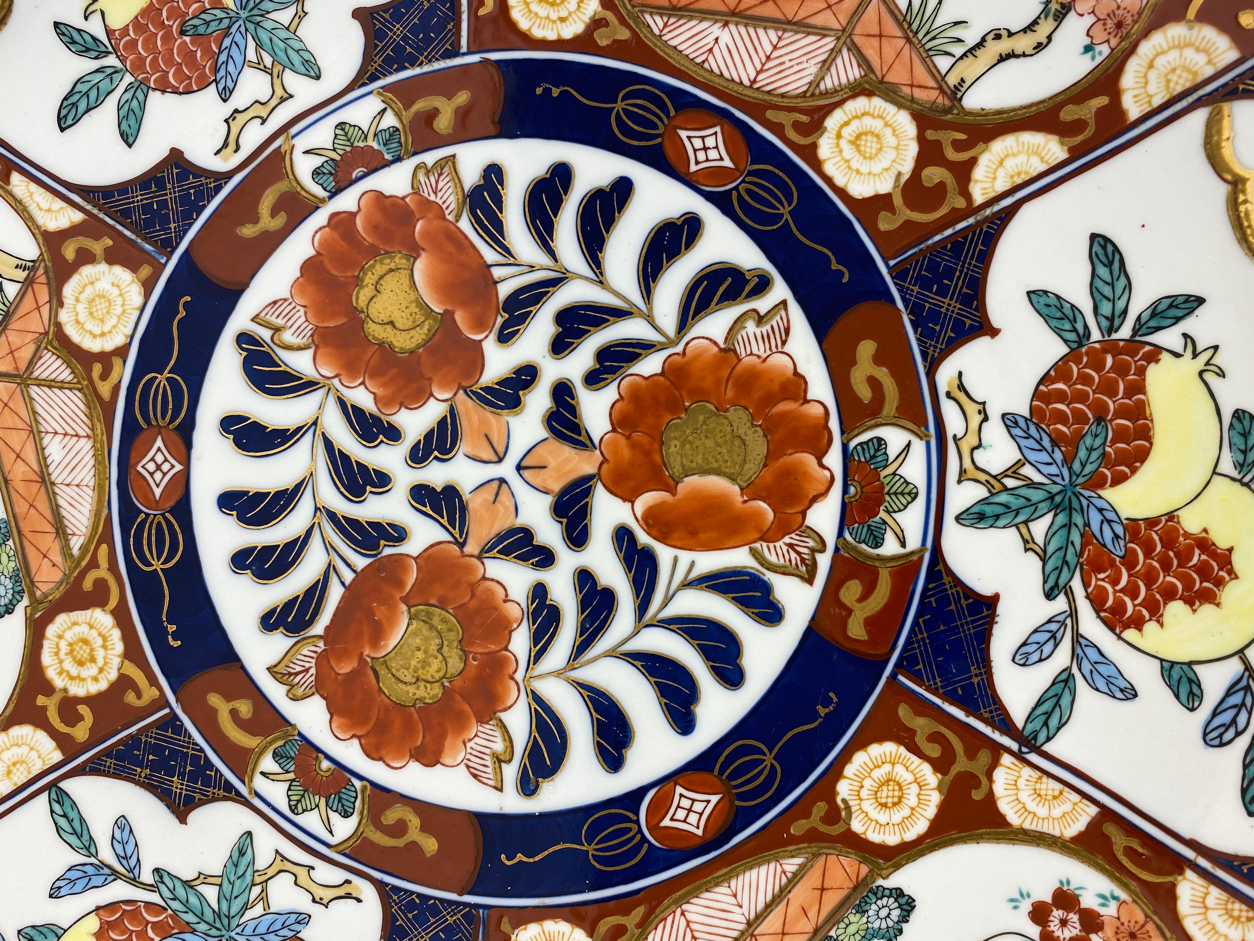 A fine Japanese Imari charger, platter or bowl. This wonderfully hand crafted decorative item is in the very good vintage condition. With an overall floral decoration in blue, orange and green colors this piece would enhance any shelf, countertop or