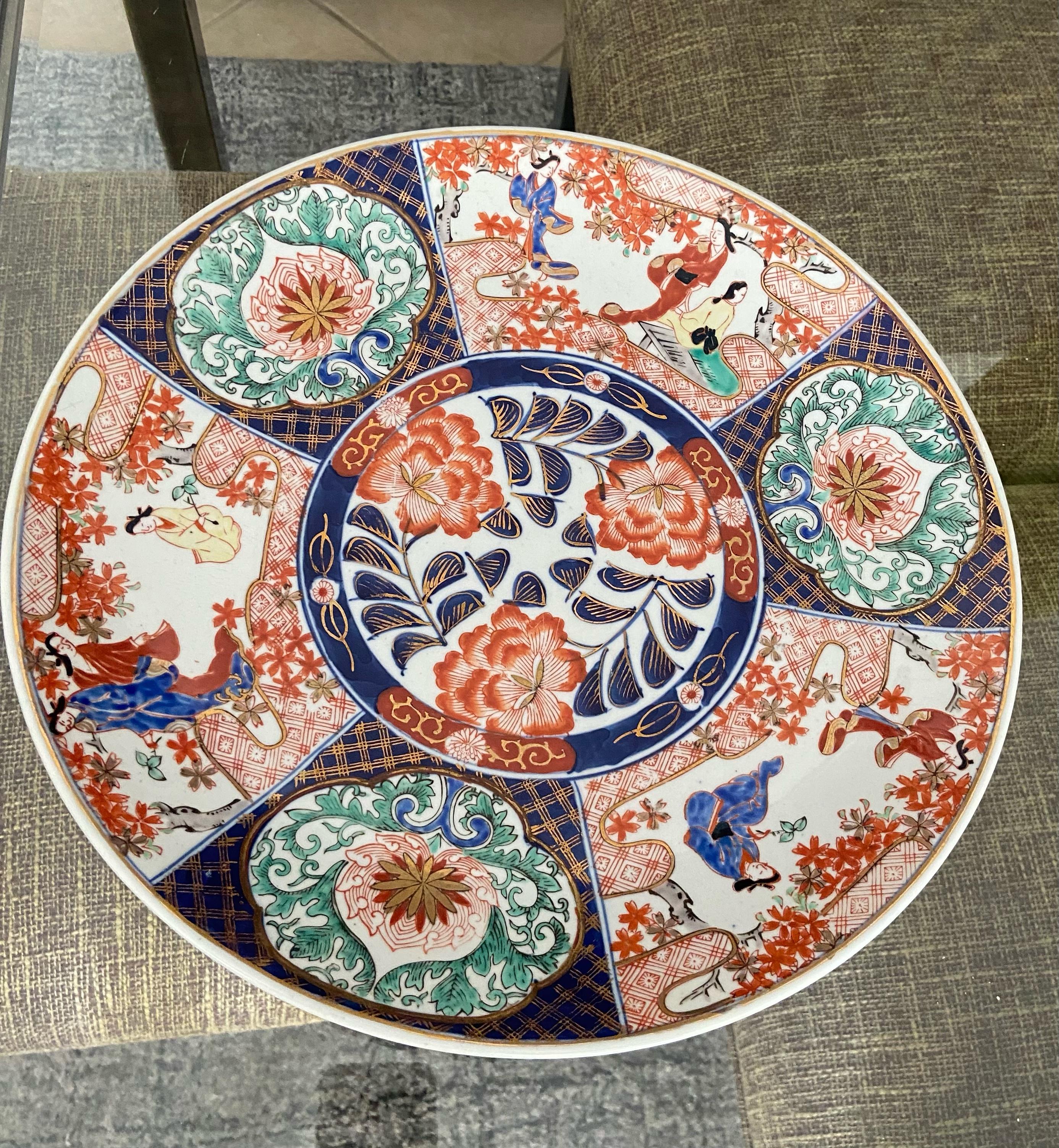 Hand painted porcelain Japanese Imari charger plate with figures and floral motif.