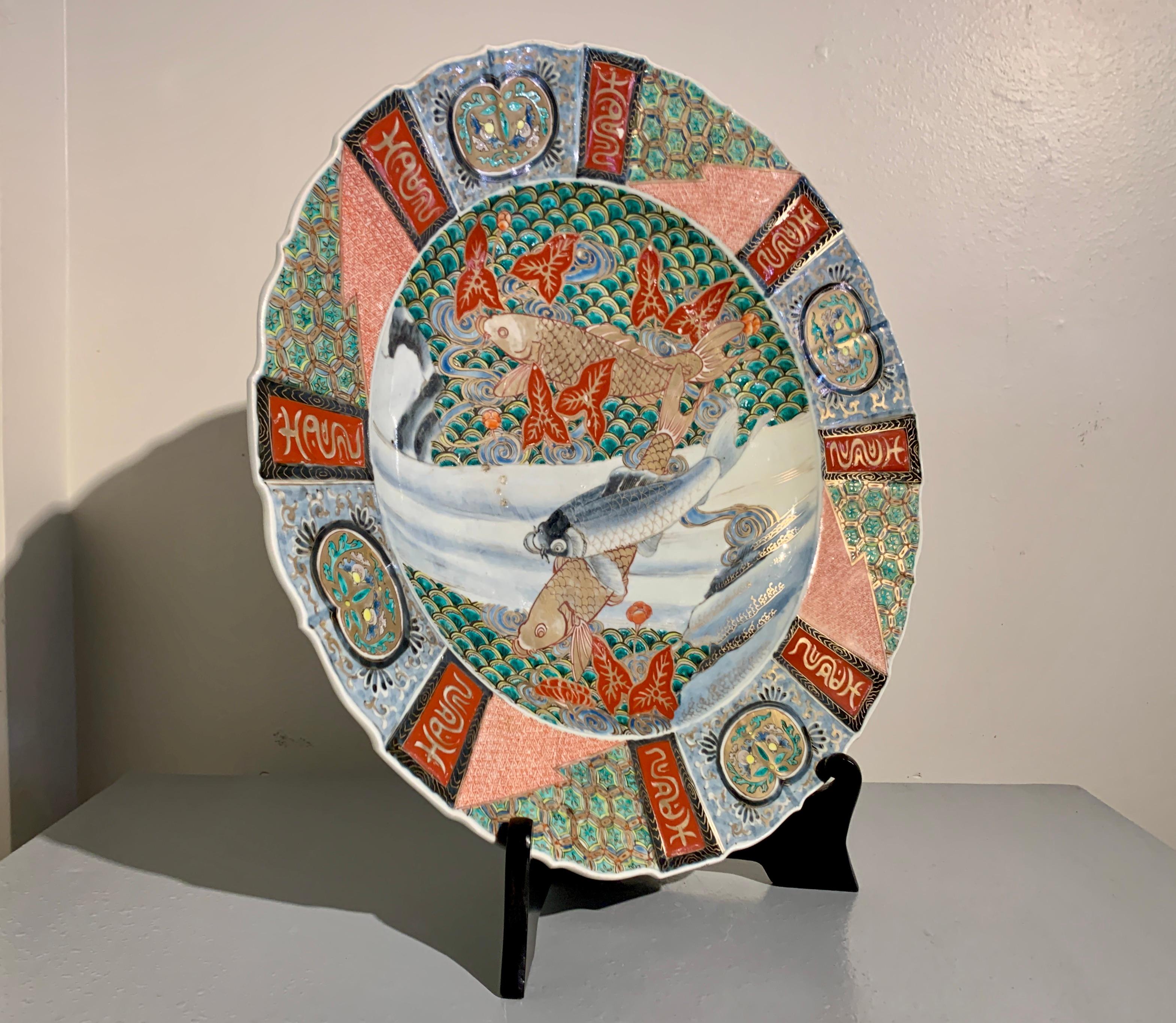 A boldly decorated large Japanese Imari porcelain scalloped edge charger with koi fish, Meiji Period, late 19th century, Japan.

The large, shallow charger features a central design of three carp, koi, two in gilt, one in underglaze blue with gilt