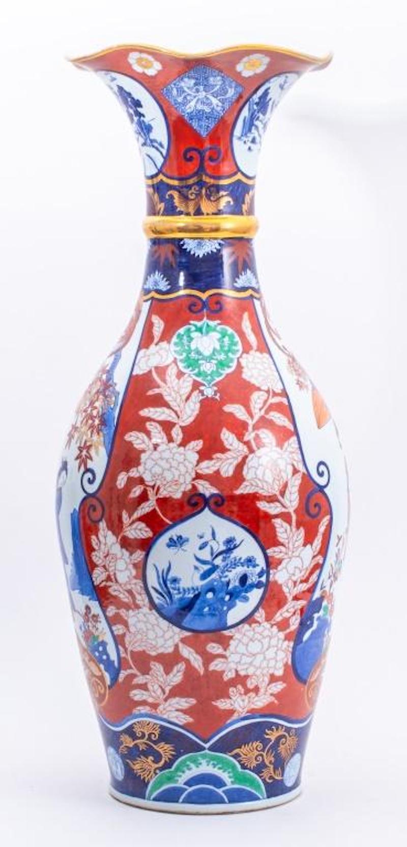 Sehr große handbemalte und verzierte / vergoldete japanische Bodenvasen aus Imari-Porzellan. Die Vase zeigt außen und innen eine handgemalte japanische Szene aus der Meiji-Zeit und hat einen trompetenförmigen Hals. Jede handgemalte Szene ist mit