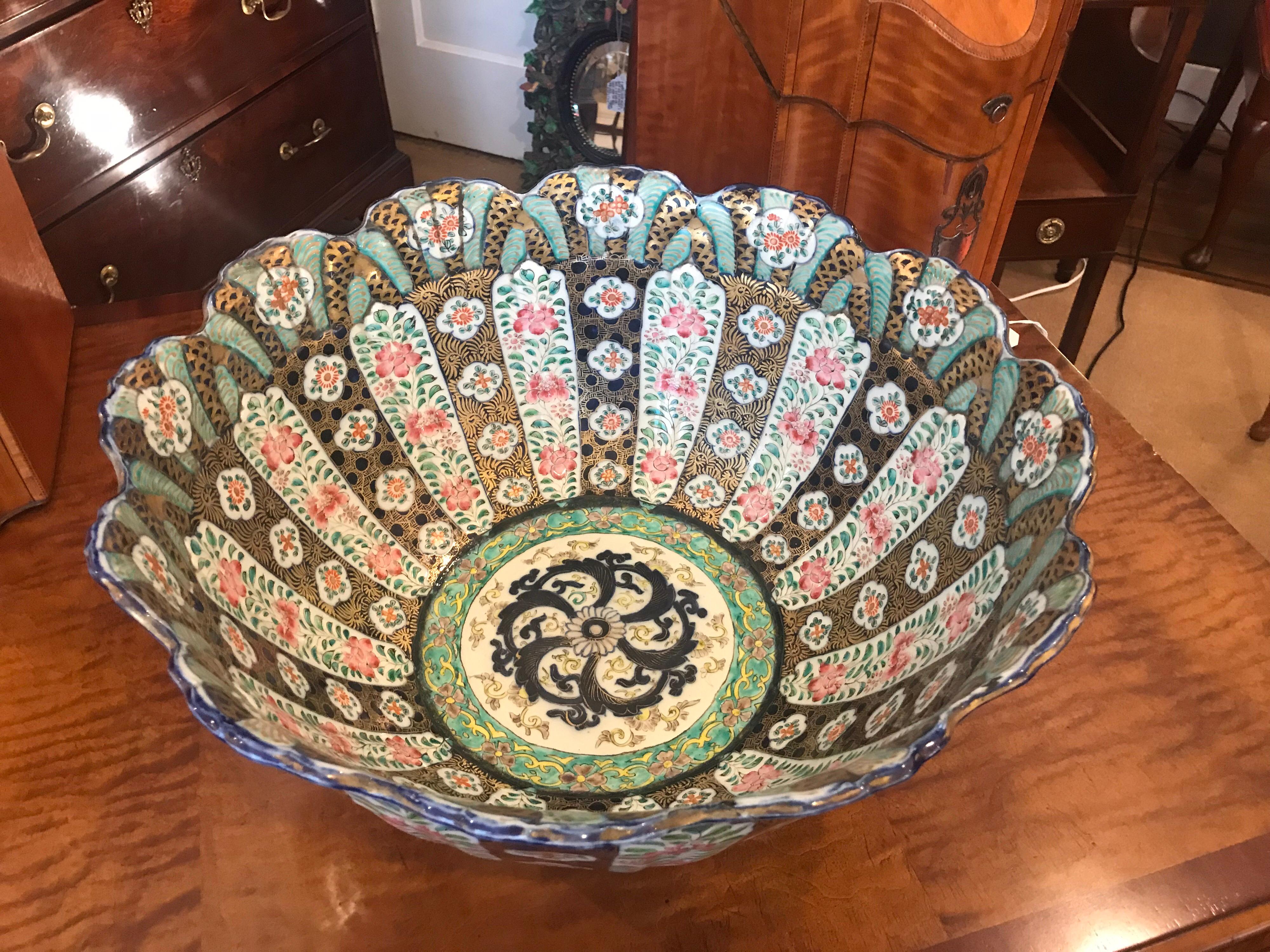 Large hand painted porcelain Japanese Imari punch bowl. The scalloped edge with white background porcelain with cobalt, pink, green hand painted pattern with all-over gilt highlights. A large and impressive 19th century porcelain bowl with an