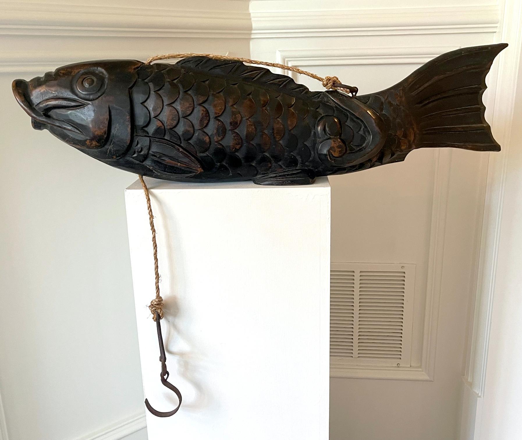 A large and impressive wood koi fish from Japan circa 1860-90s of late Meiji Period. Hand-carved from a piece of solid wood, the sculpture of this type is known as Jizai Kagi in Japan and function as a leveling pulley for the attached hearth hook.