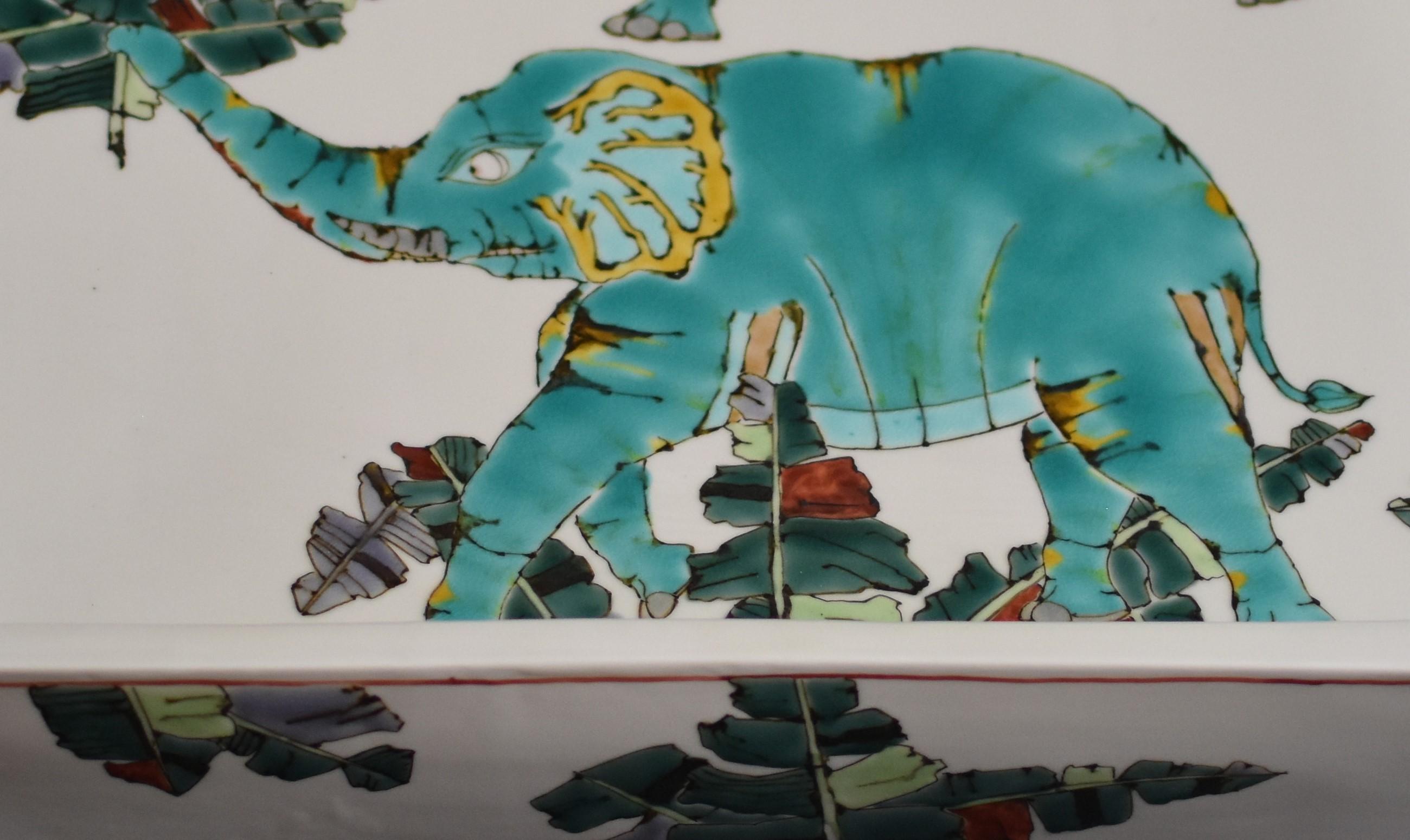 Très grand et exceptionnel chargeur/centre de table en porcelaine japonaise contemporaine, peint à la main en vert et turquoise sur un corps carré surélevé de forme étonnante, avec une interprétation unique des éléphants. Il s'agit d'un chef-d'œuvre