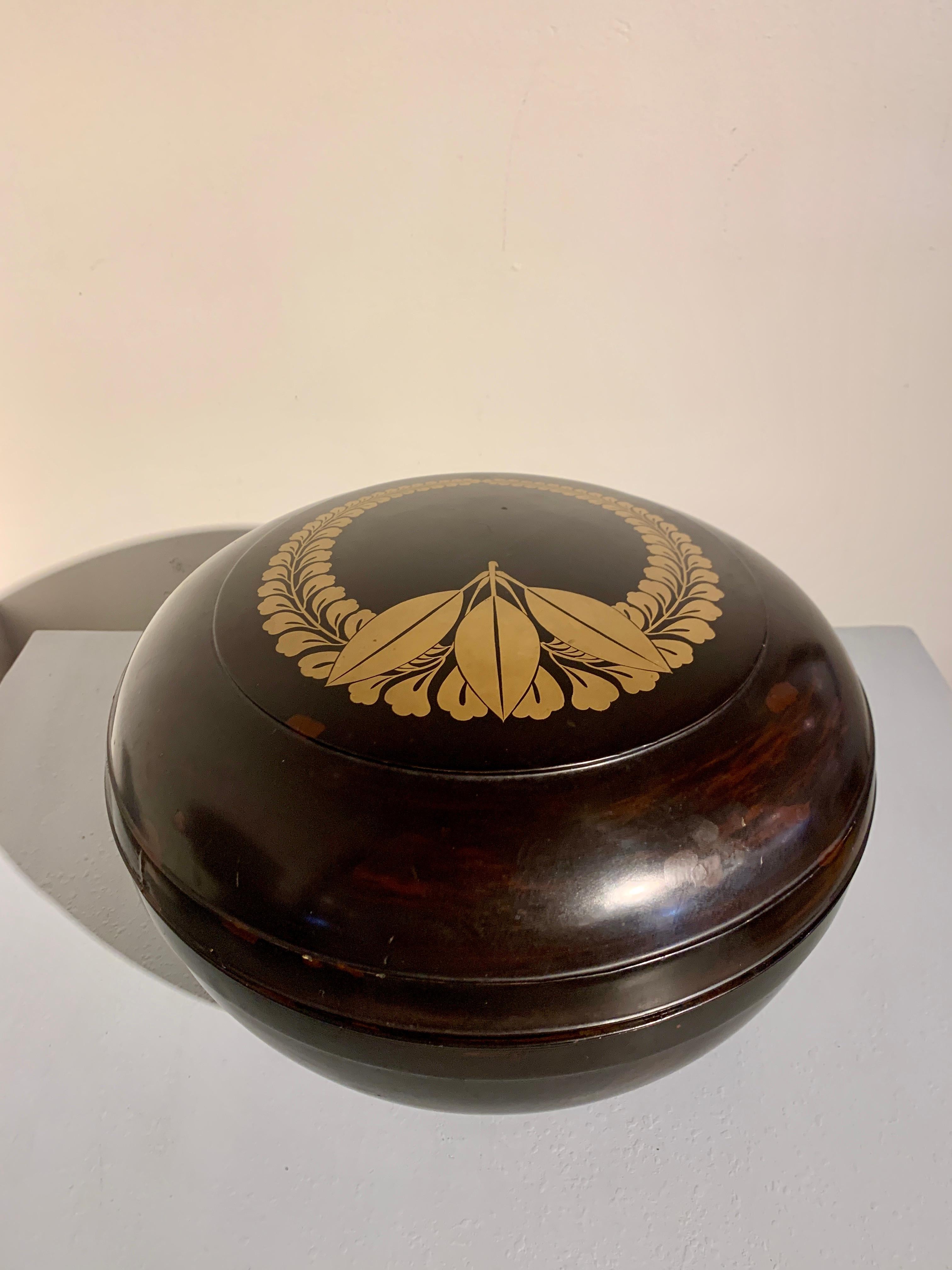 A large Japanese black lacquer and maki-e lacquer decorated footed pedestal bowl and cover featuring the Fujiwara mon, Meiji Period, circa 1900, Japan.

The elegantly proportioned oversized container takes the form of a large and deep bowl supported