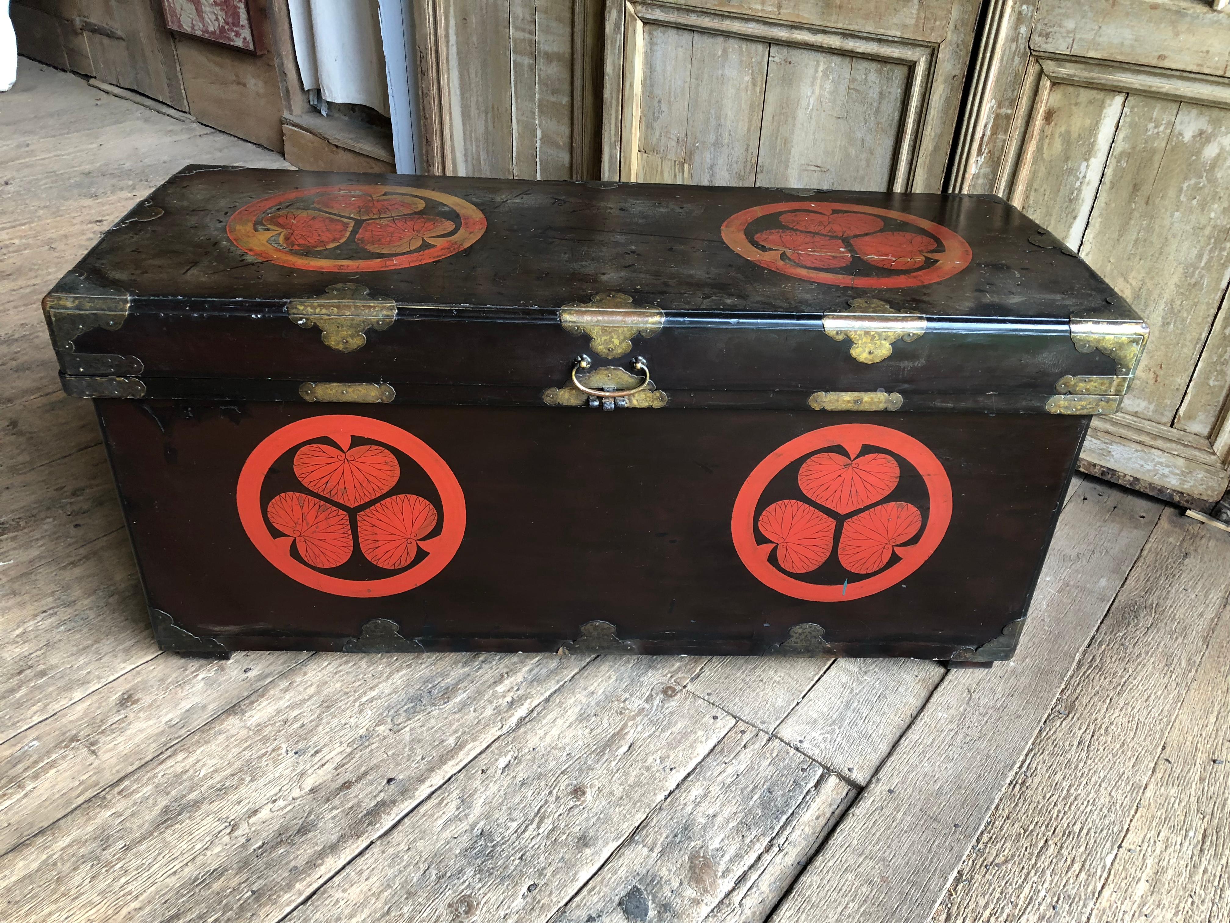 A large Japanese lacquered dowry chest from the Edo period, early to mid-19th century, with the “Mon” or symbol of the Tokugawa Shogun Clan. Of unusually generous proportions, with a slightly domed lid. Large handles on the side were used for