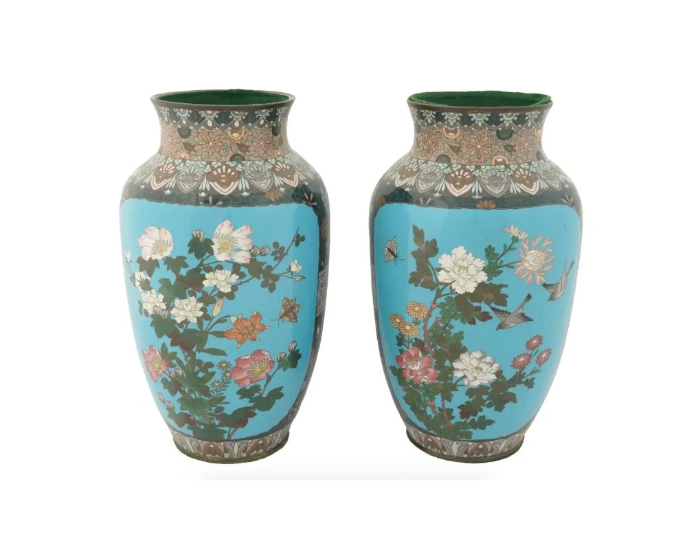 A pair of antique Japanese rounded copper vases with cloisonne enamel design. Late Meiji period, before 1912. The vases are decorated with floral ornaments and large panels depicting flower branches and birds against the turquoise background on the