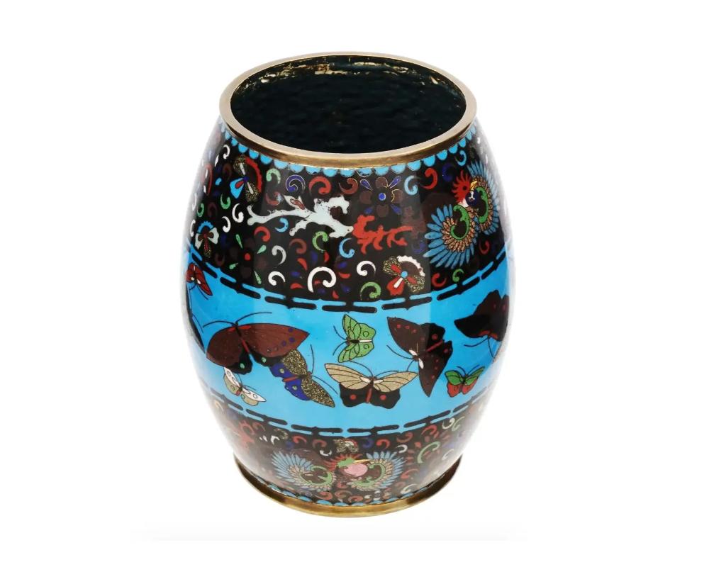 A large antique Japanese copper vase with cloisonne enamel design. Barrel shape. Floral ornaments and central butterfly motif against the turquoise blue background.
Late 19th Century
Dimensions: H 7 1/4 in. All measurements are