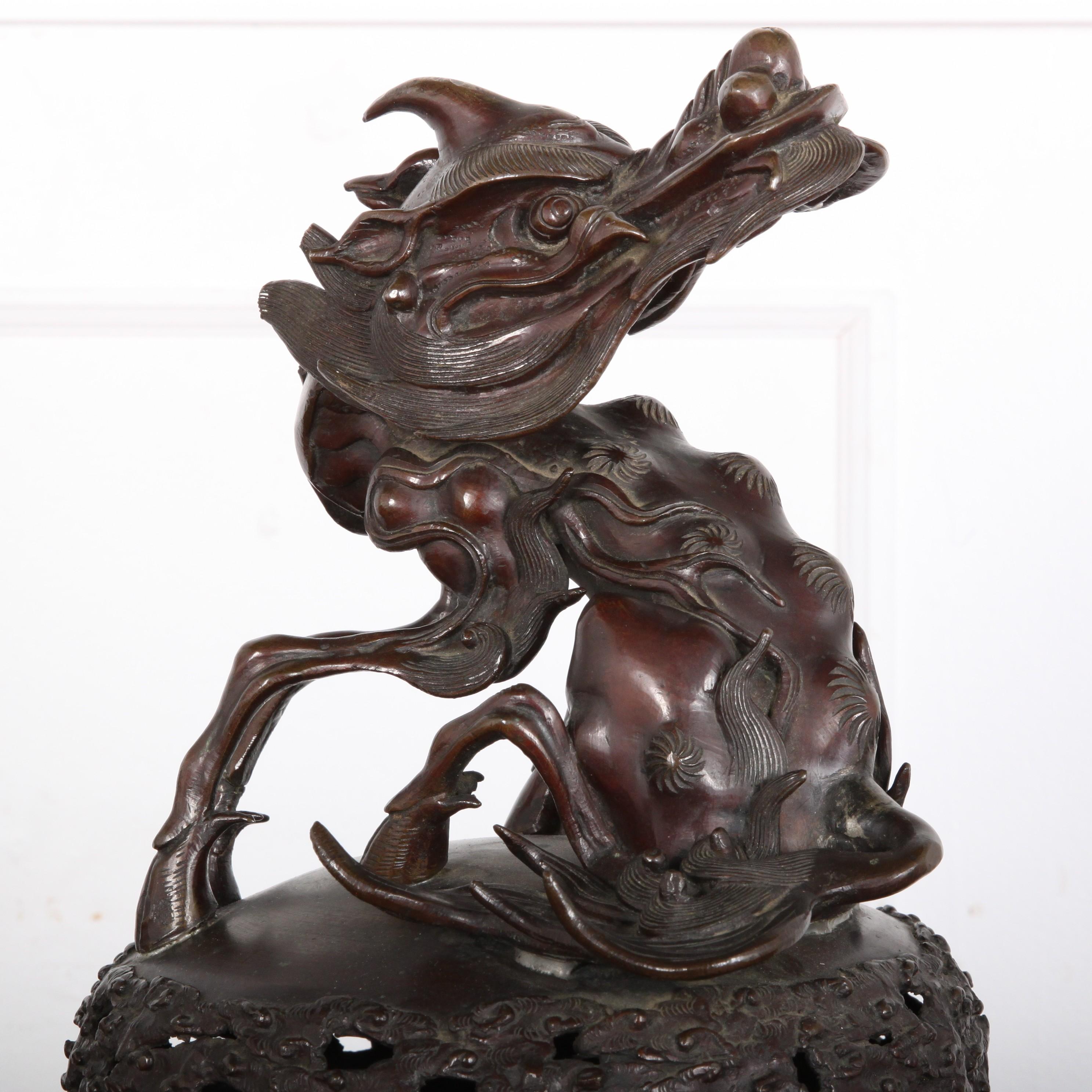 An unusually-large solid bronze Japanese censer or incense burner, the body raised up on a three-legged base and with phoenix and humming bird details. The top features a highly-detailed and dramatic Kirin figure.