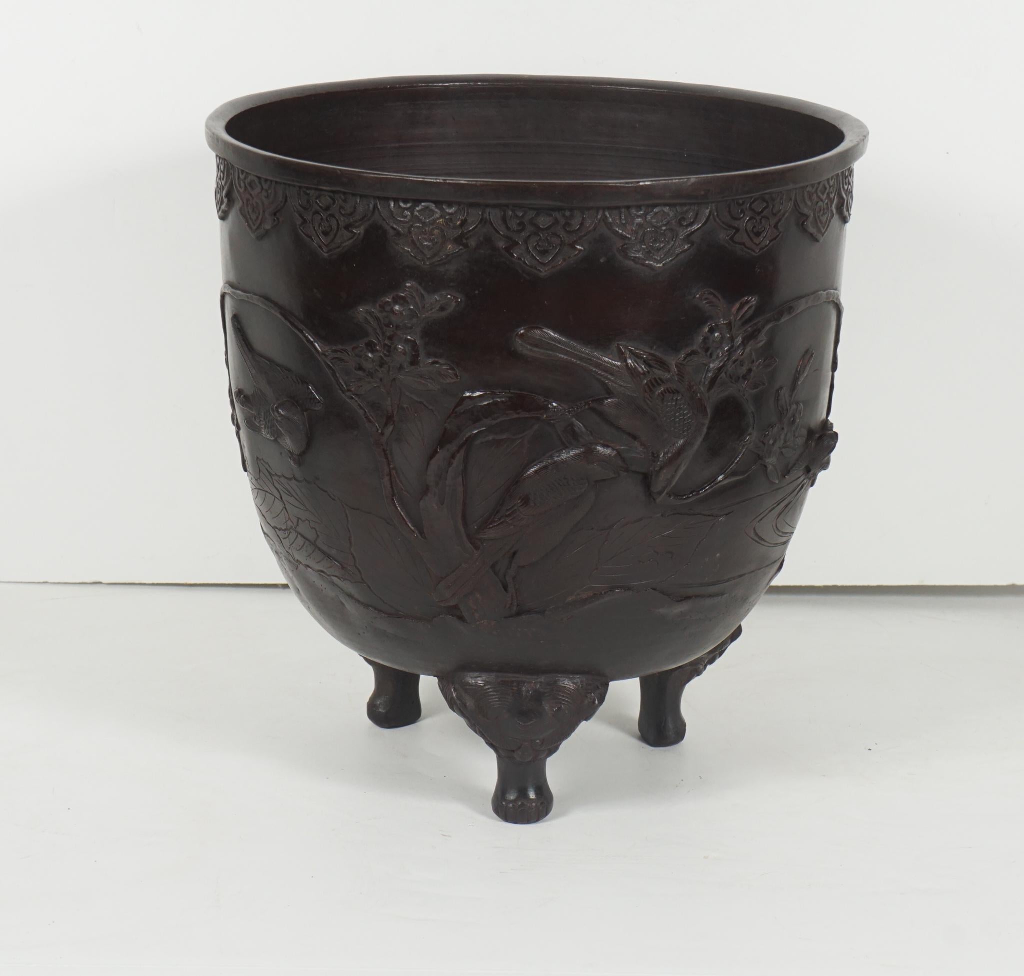 This cast bronze censor is from Japan and was made circa 1880. Raised up on three legs which issue from demons mouths the container is cast with reliefs of sparrows in flight in a foliated and wooded landscape. All cast in fine detail with high and