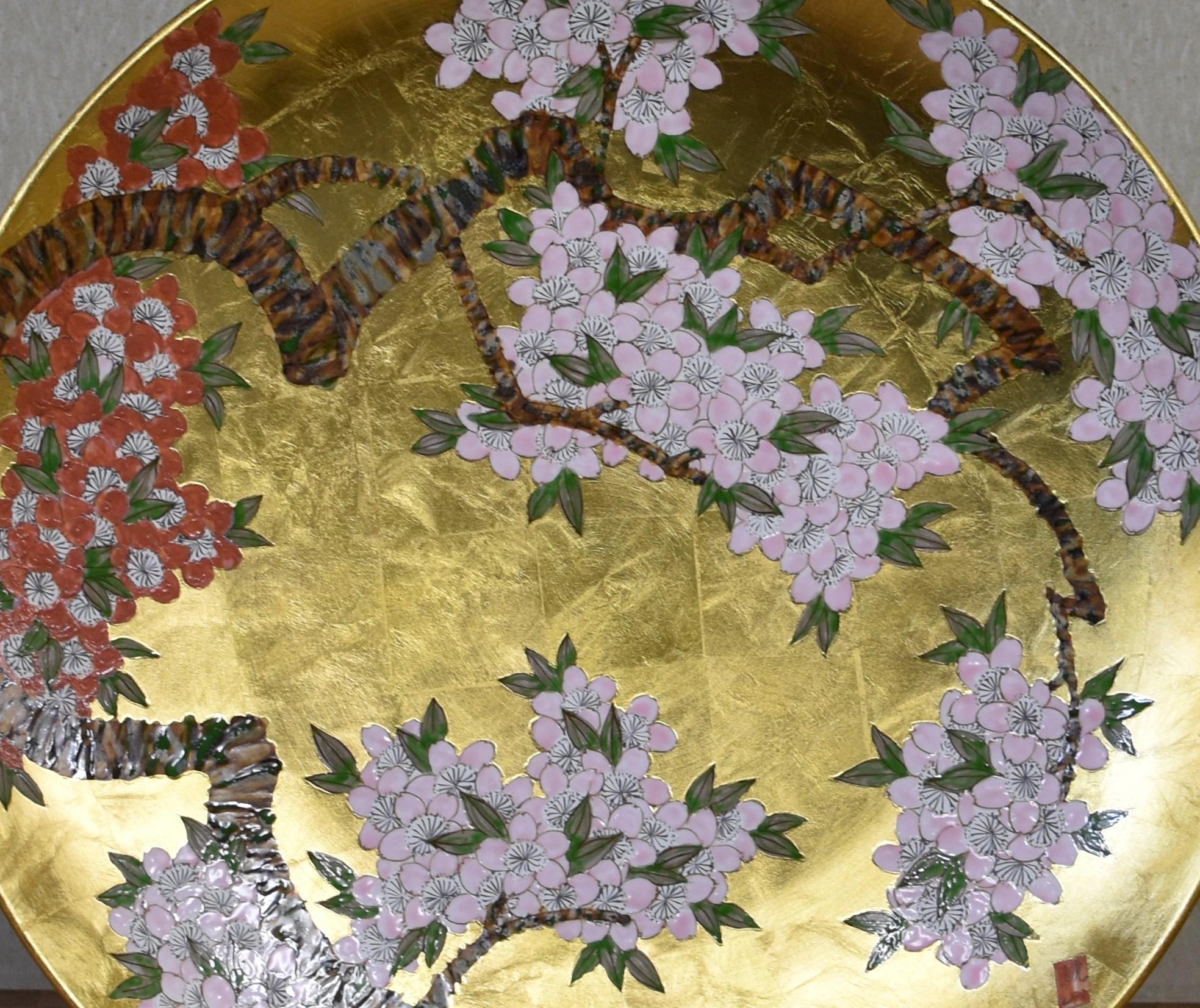 Exquisite large Japanese contemporary decorative porcelain charger intricately hand-painted showcasing clusters of cherry blossom in soft pink and red on graceful branches, set against a breathtaking gold leaf background. This is a masterpiece by a