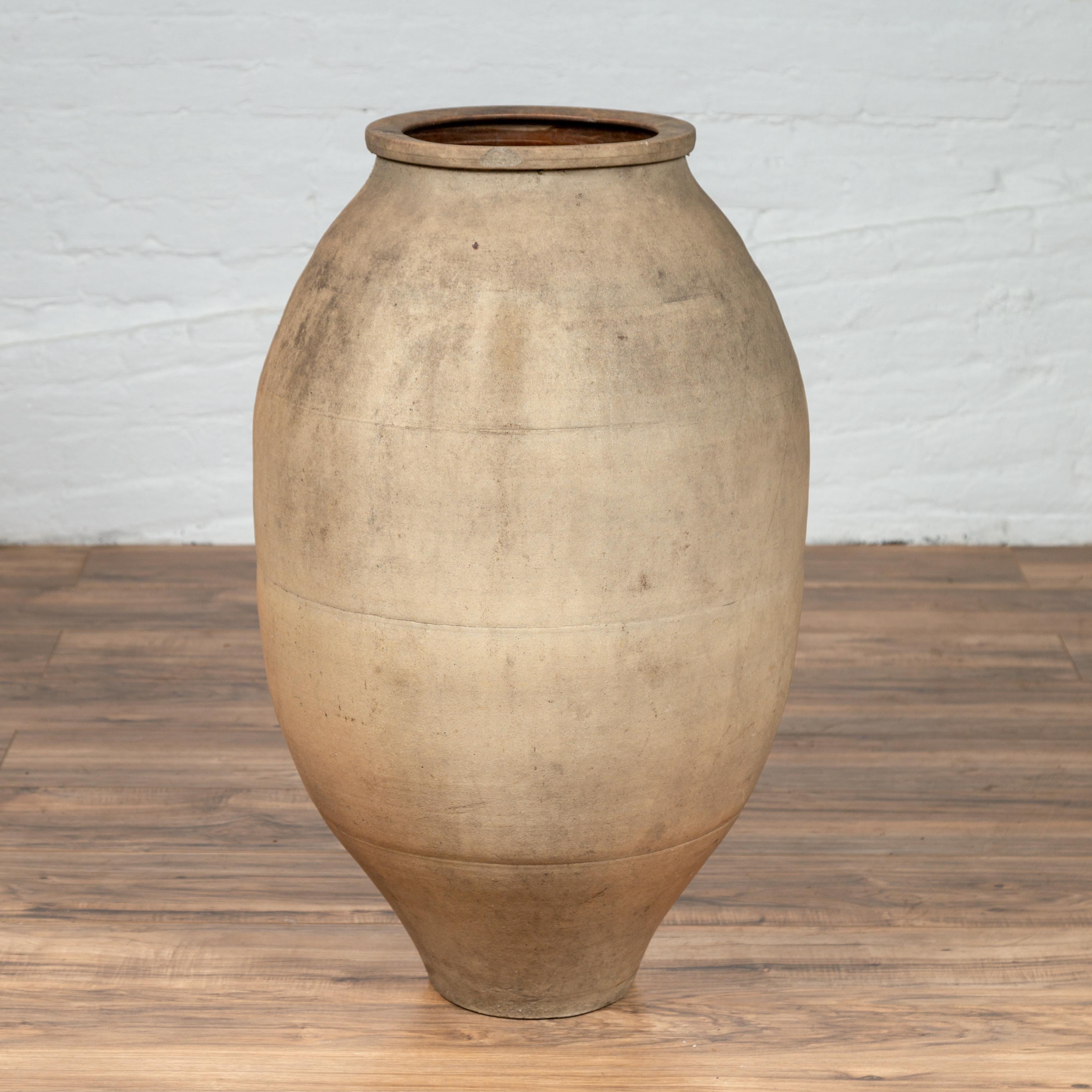A tall Japanese Shigaraki stoneware grain storage urn from the early 20th century with beige sand patina. Born in one of the six ancient kilns of Japan, this large Shigaraki urn is made of sandy clay typical of the region, and features a rounded