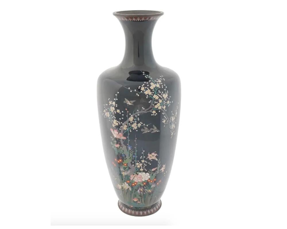 An antique Japanese Meiji Era Silver and enamel vase. Circa: Late 19th Century The baluster form vase is enameled with polychrome images of blossoming flowers and plants and birds made in the Cloisonne technique on a black ground. The borders are