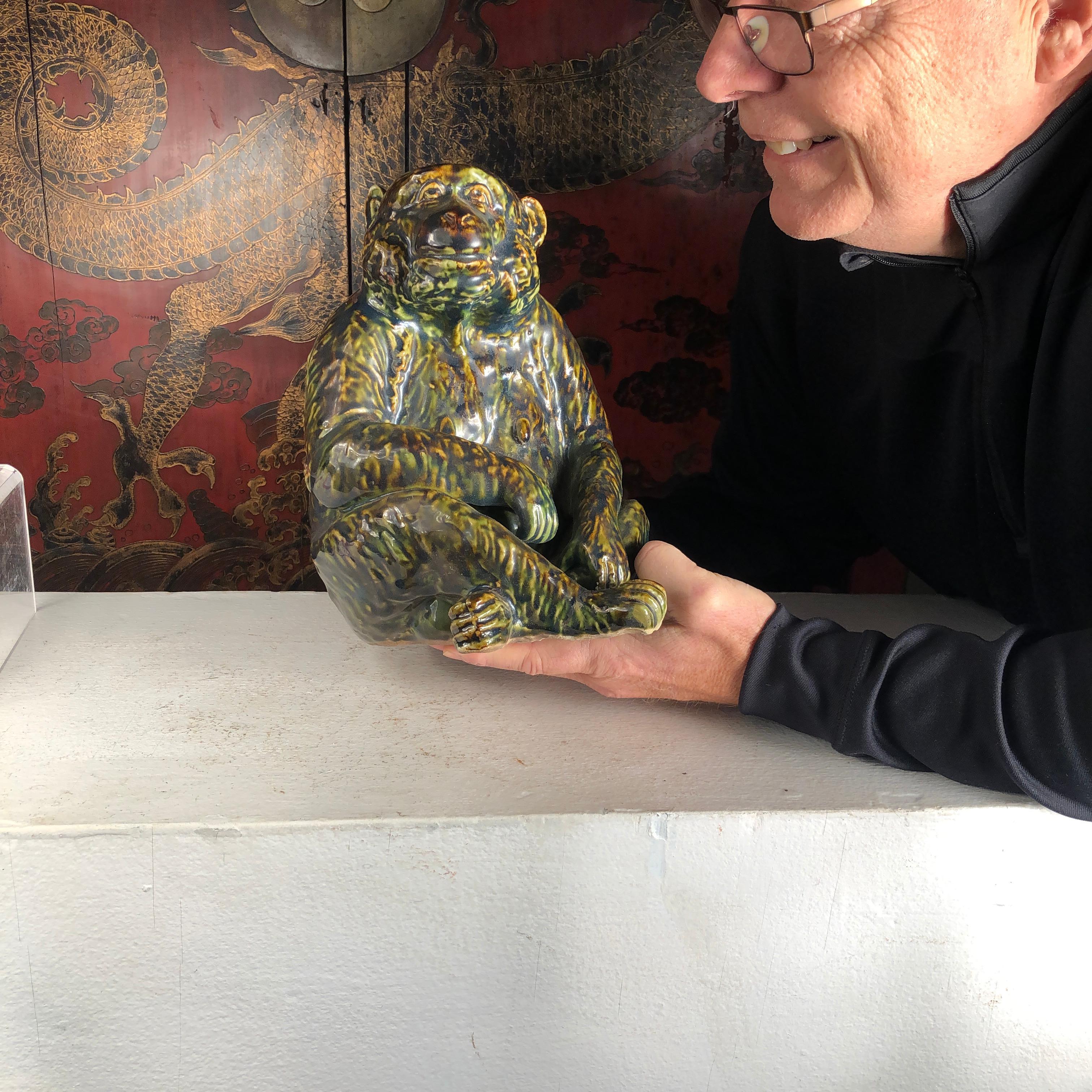 Japan, a fine large scale handmade and hand painted friendly seated monkey ceramic sculpture crafted in Japan's famous Oribe green glaze.

The handsome and friendly faced ceramic animal has finely detailed ears, eyes, mouth, hands, legs, and hand