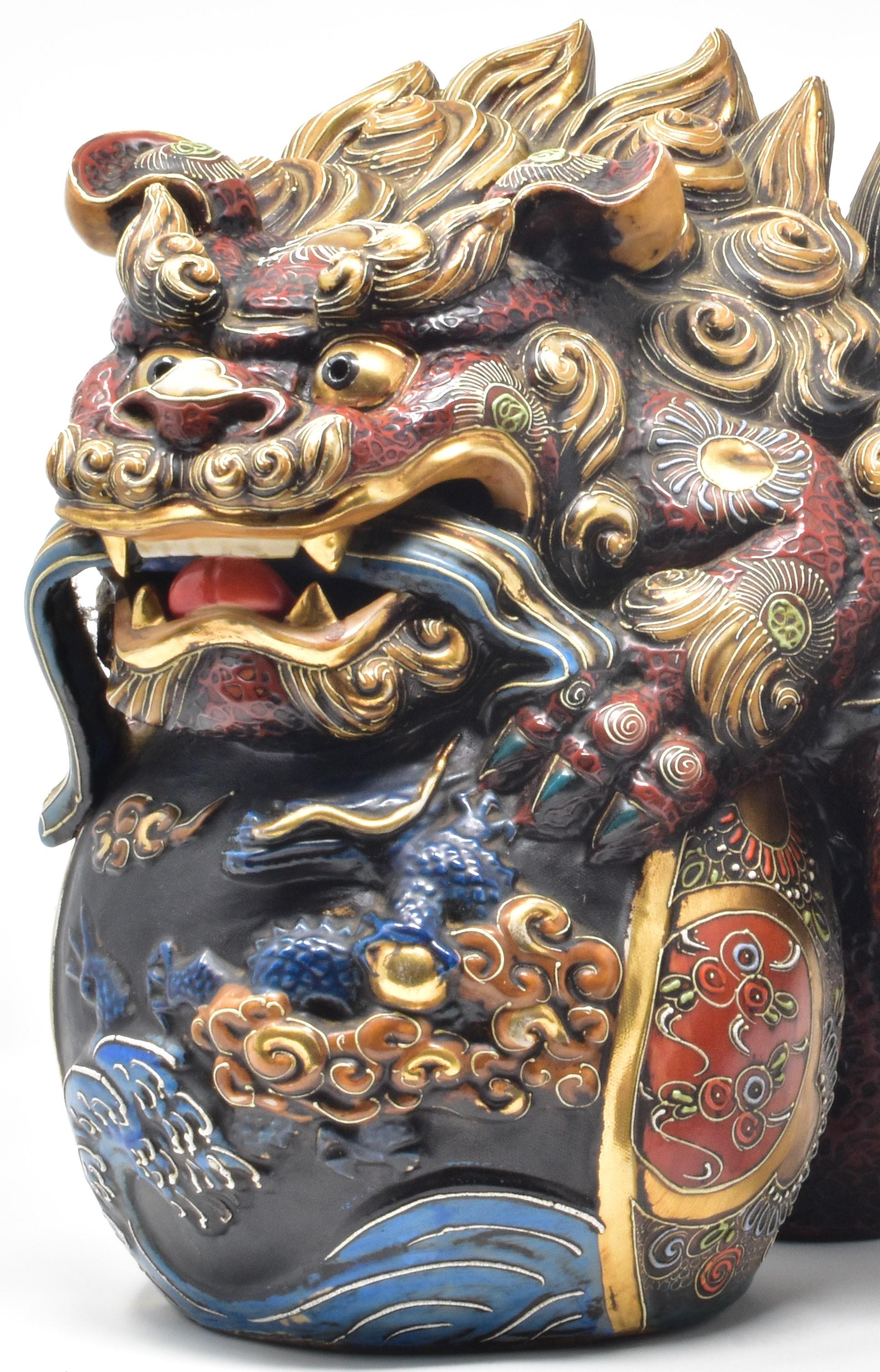 This large vintage Japanese ceramic shishi lion signed “Kutani Sueyoshi” is from
the early postwar period. Extremely intricately hand painted in the five colors of the traditional Kutani palette (yellow, red, blue, green and purple) and extensively