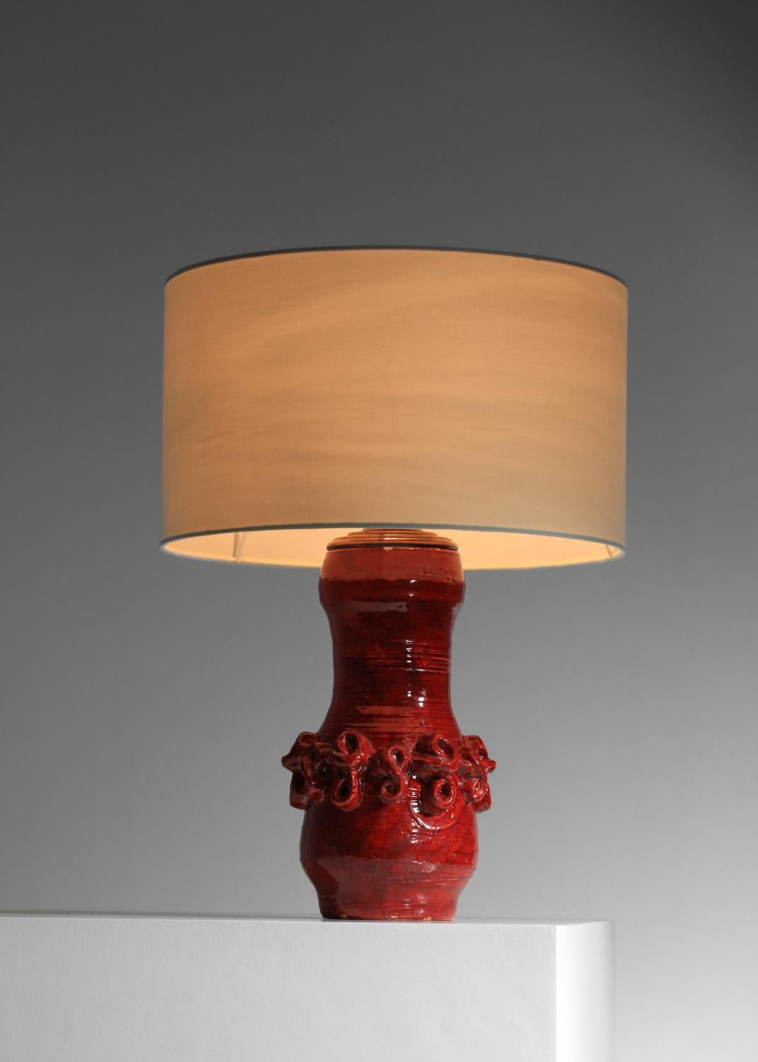 Lampada da tavolo degli anni '50 del ceramista francese Jean Austry. Base in ceramica smaltata di rosso con un disegno astratto al centro della lampada. Condizioni vintage molto belle con una bella patina di età sulla base, lievi scheggiature sul