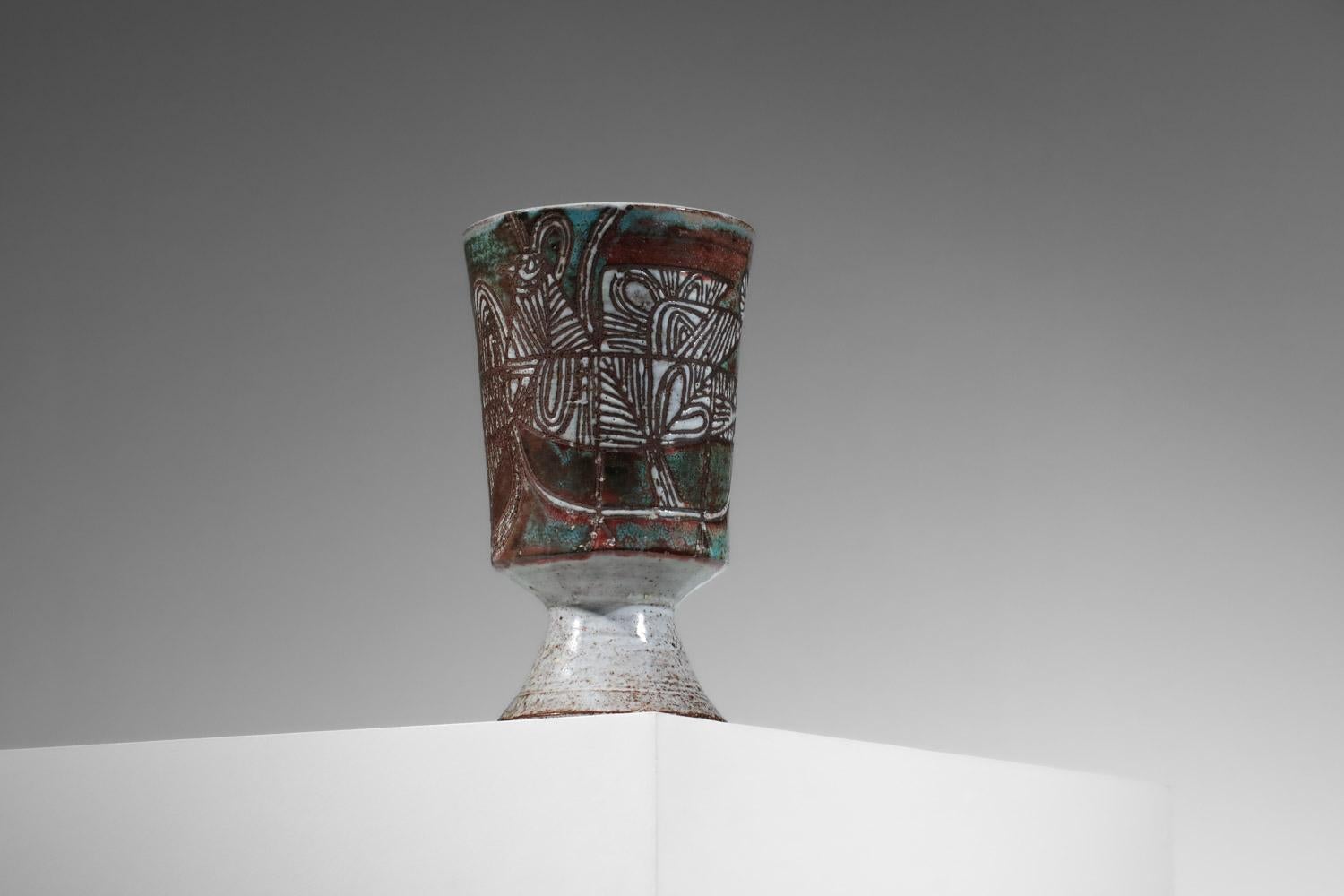 Grand vase des années 50 de l'artiste français Jean Derval. Céramique émaillée dans des teintes rouges, blanches et vertes avec sur l'ensemble un décor géométrique représentant une poule typique du style de l'artiste. Très bel état vintage,