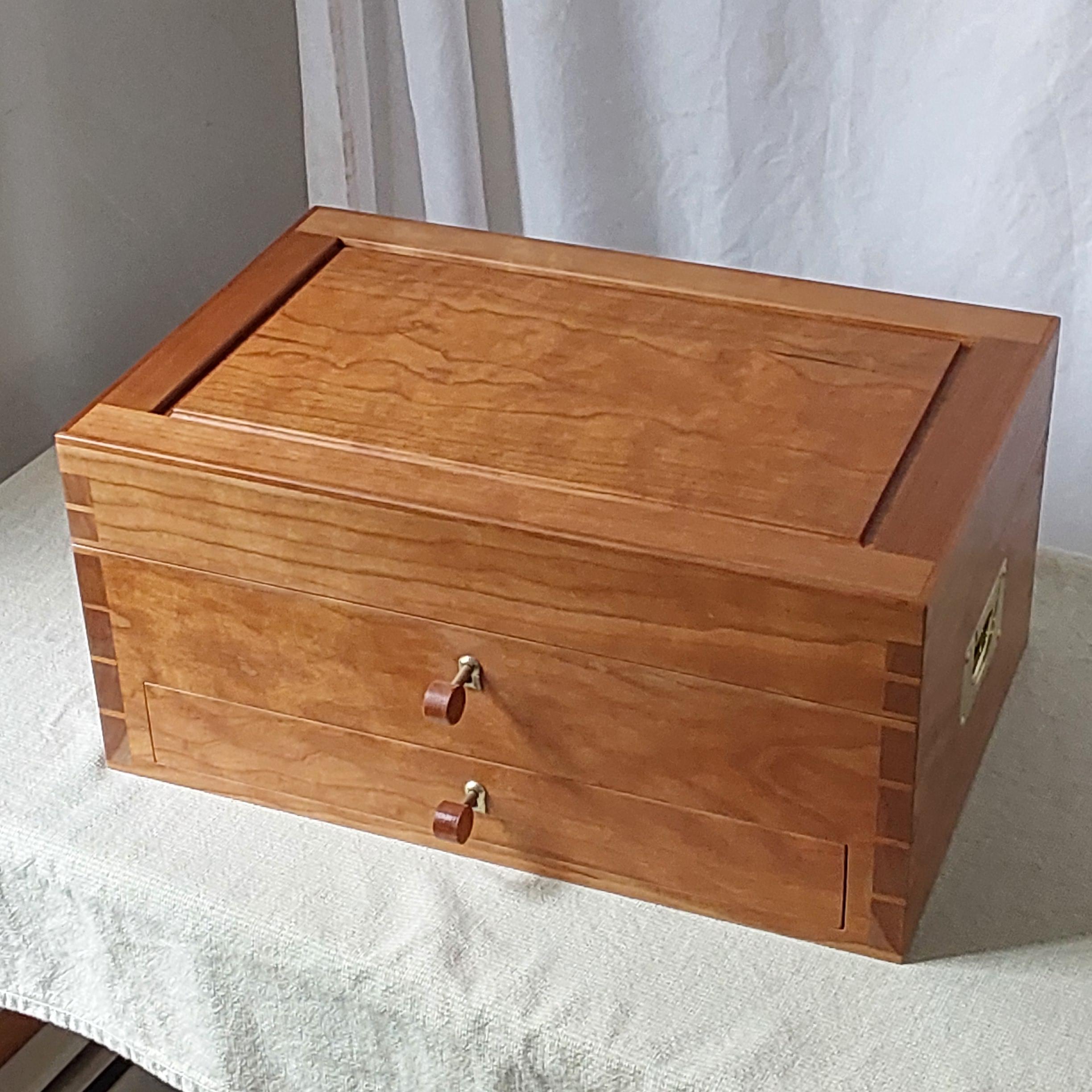 Handcrafted Cherry Jewelry Box with Drawer by David Klenk

Meticulously handcrafted in West Gray, Maine by artisan David Klenk, this elegant jewelry box combines traditional craftsmanship with refined details. Built entirely from solid cherry wood,
