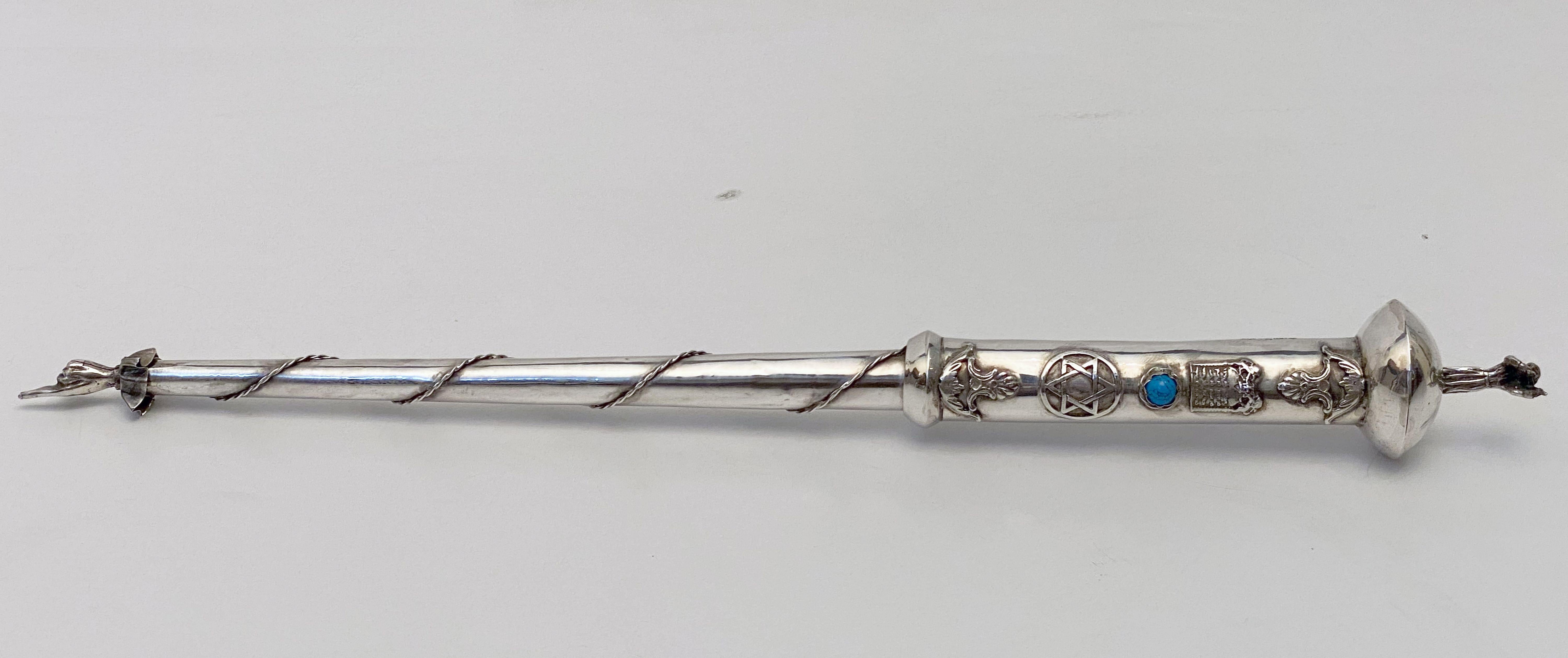 A fine Jewish yad or torah pointer of silver featuring a robed man playing a violin or fiddle on the handle end, with a traditional pointed finger hand on the other end. With decorative blue stone and Star of David. A handsome find for the Judaica