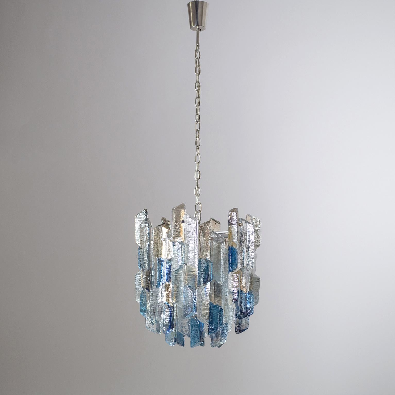 Rare J.T. Kalmar chandelier from the 1970s. 18 very thick (1.5 inches) and heavily textured glass elements, partially tinted blue and smoke on the back, are mounted in three tiers on a lacquered body with nickeled chain, canopy and knobs. The sheer