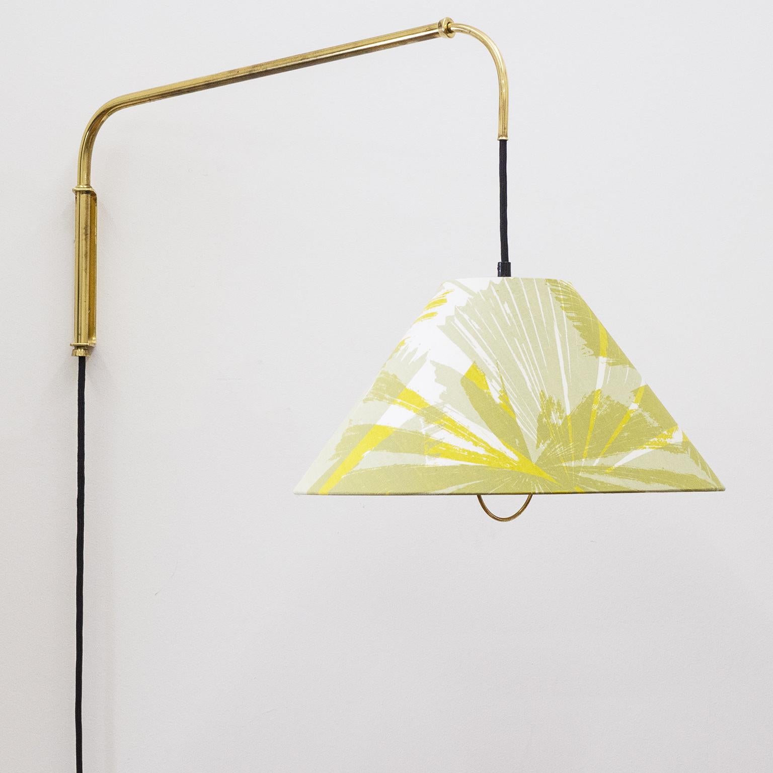 Rare large telescopic swing-arm wall light by J.T. Kalmar, circa 1950. The all brass arm can be extended and swiveled and the shade can be adjusted up-and-down by means of a brass grip on the shade and a solid brass counterweight on the cord. This