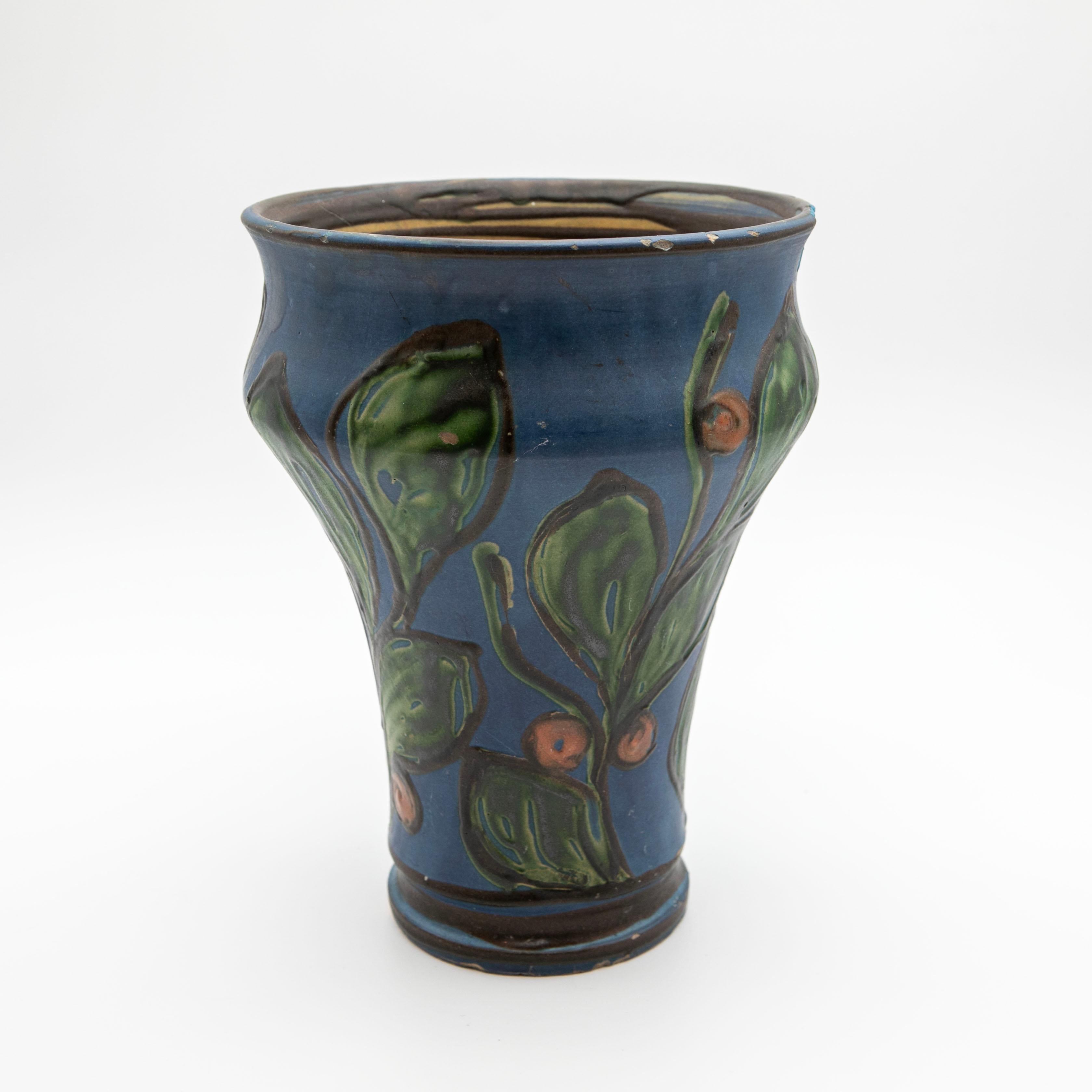 Un grande vaso in ceramica di Kähler con una base di smalto blu intenso, decorato con la tecnica del corno di mucca che forma intricati motivi floreali e di foglie con smalti verdi, gialli e rossi.
Firmato: HAK in basso (Herman A.