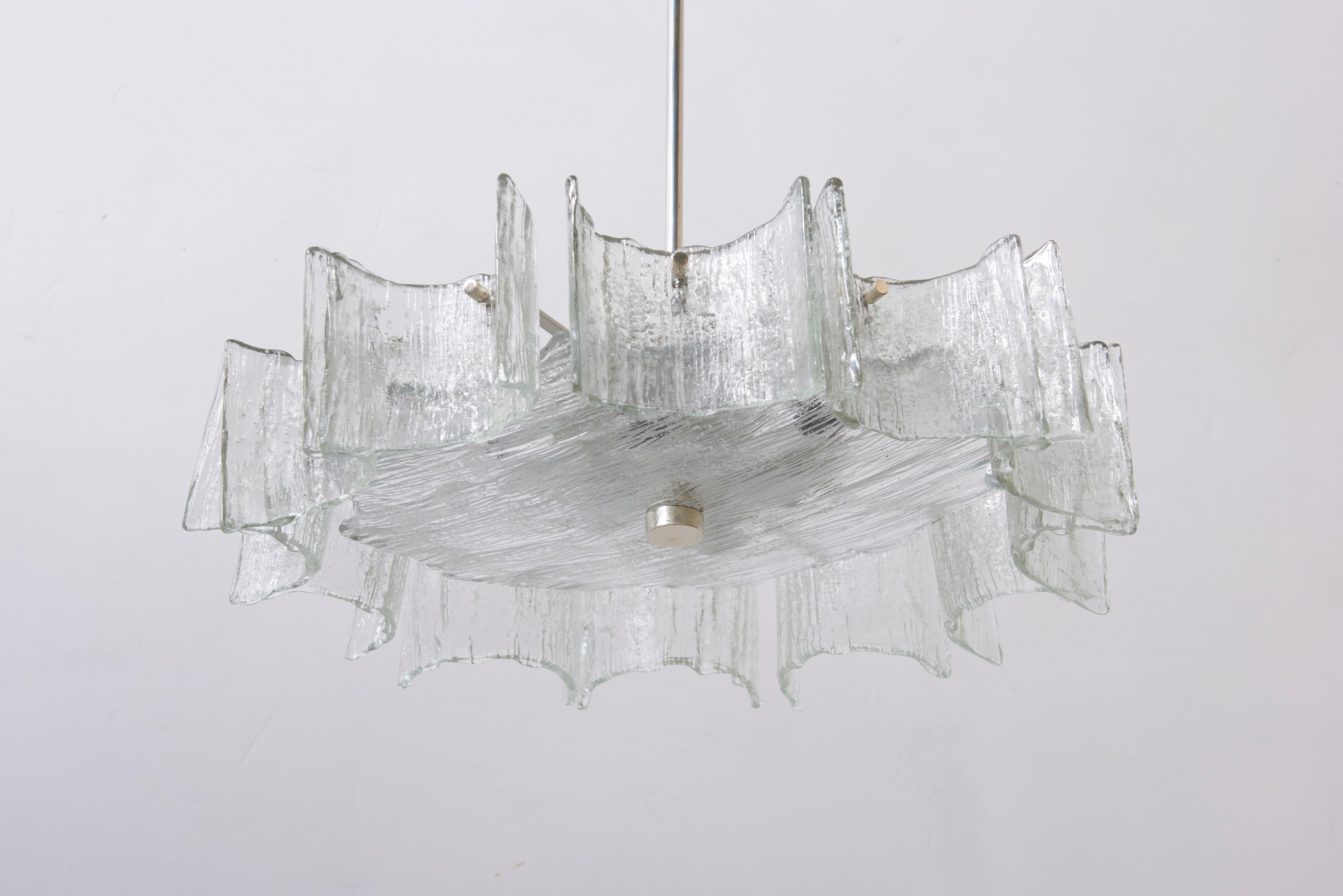 Original designed vintage glass chandelier with molded clear iced glass. One floating glass circle in the middle and 12 moon shaped glass parts mounted at the circle, lit by 6 E27 bulbs. A beautiful natural luminous chandelier for your living room.