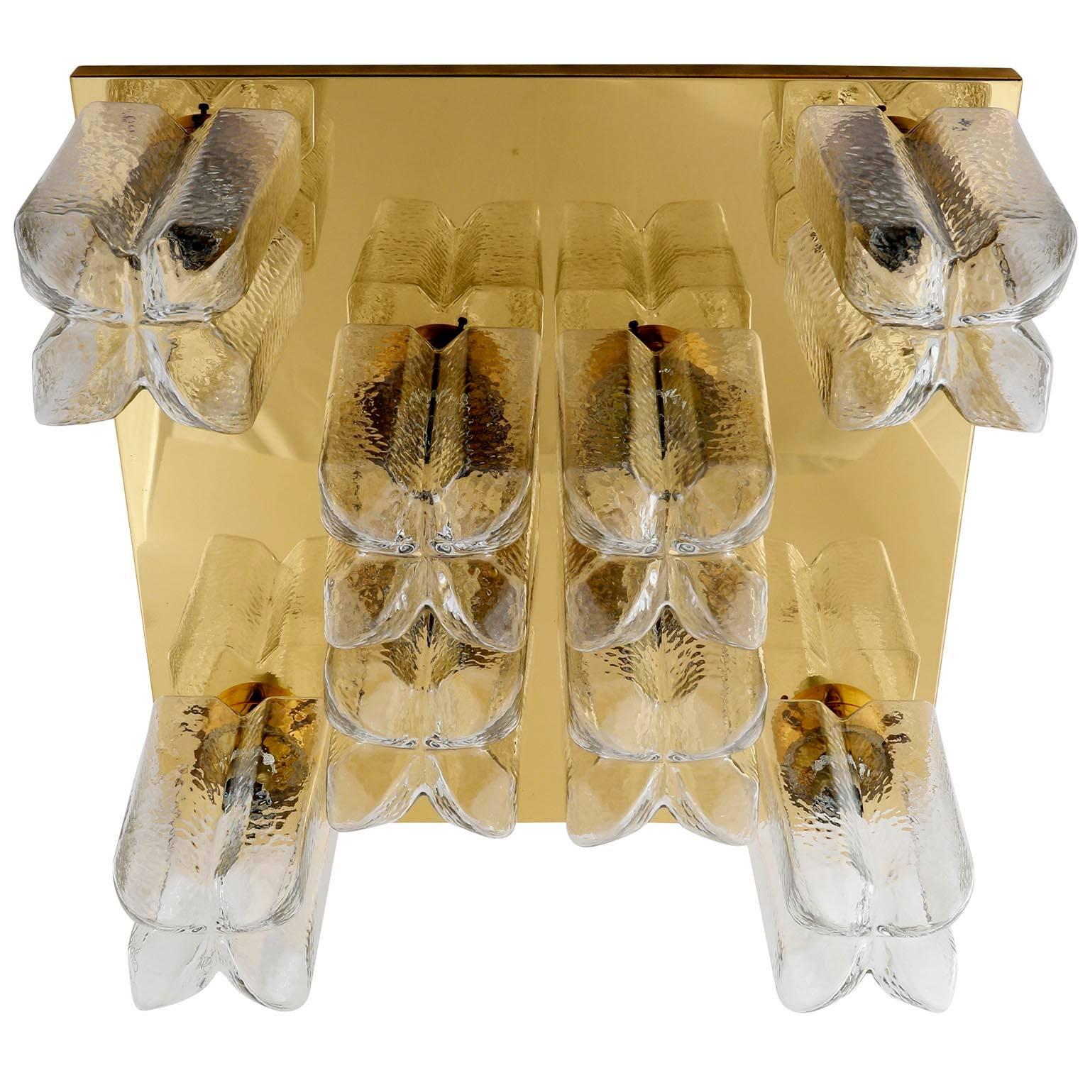 A large and square light fixture by Kalmar, Austria, manufactured in midcentury, circa 1970 (late 1960s or early 1970s).
It is made of polished brass and cast glass. There are eight standard screw base bulbs up to 60W per bulb which are covered