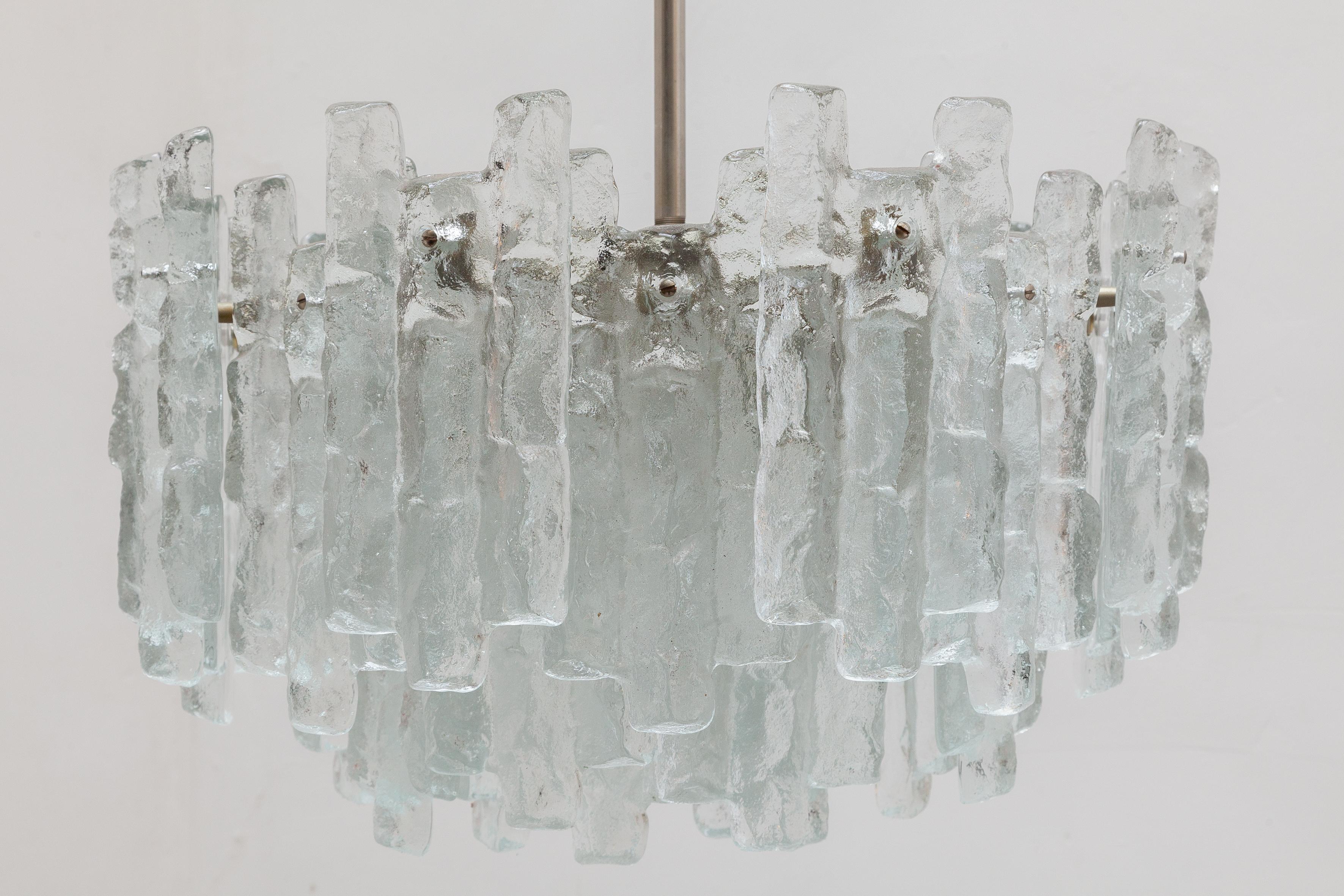 Extraordinary chandelier made by Austrian company Kalmar. Consists of three layers and 32 pieces of solid ice block glass on a silver base. The chandelier-lit by twelve bulbs. Weight is more than 30 kgs!

Three tiers of ice block glass Lit by 12