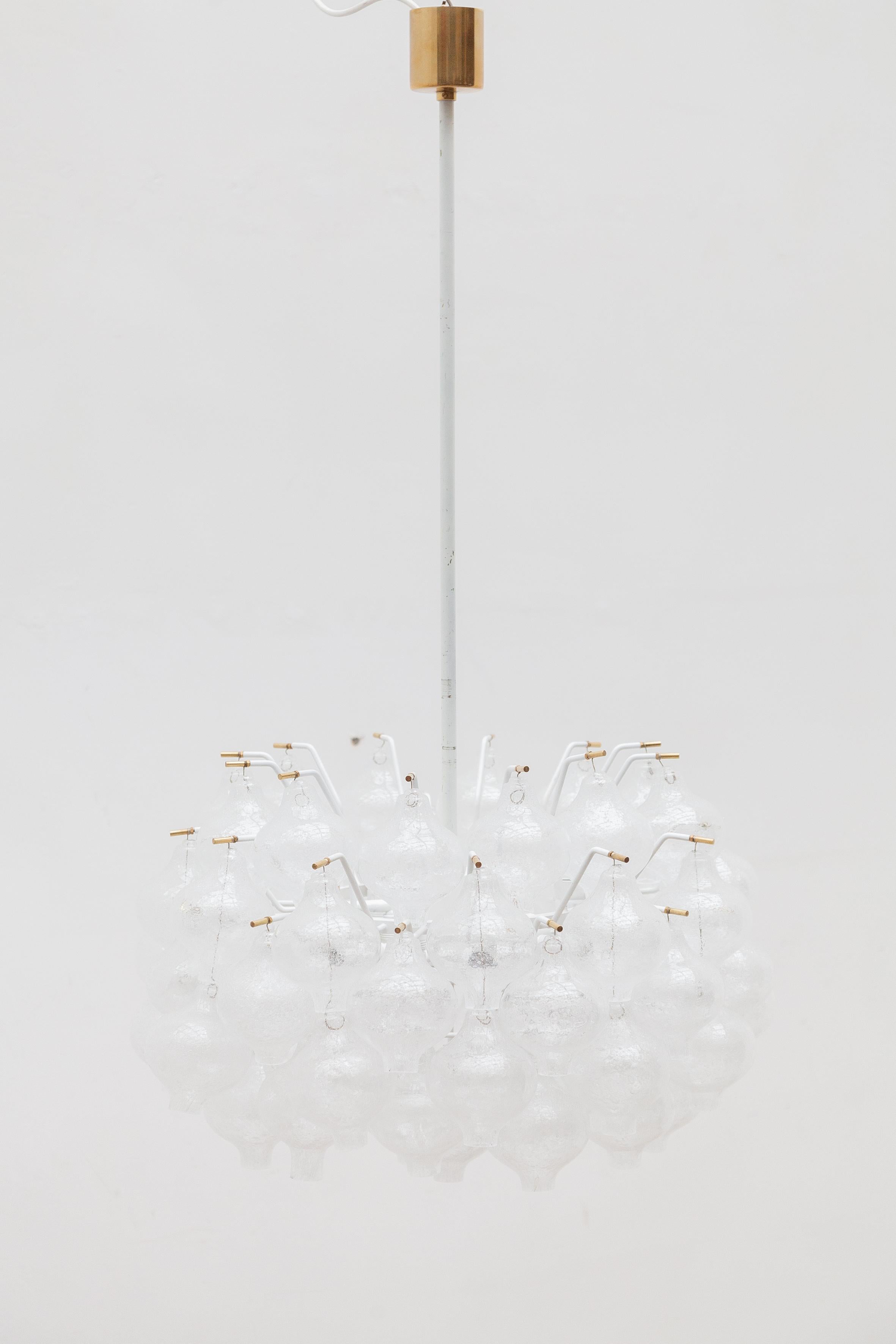 A large impressive 'Tulipan' chandelier with five-layered onion shaped glass elements, designed by J.T. Kalmar in the 1950s.Every glass onion has a small arm holding it up, with beautiful brass details at the end. The frame of the lamp is white
