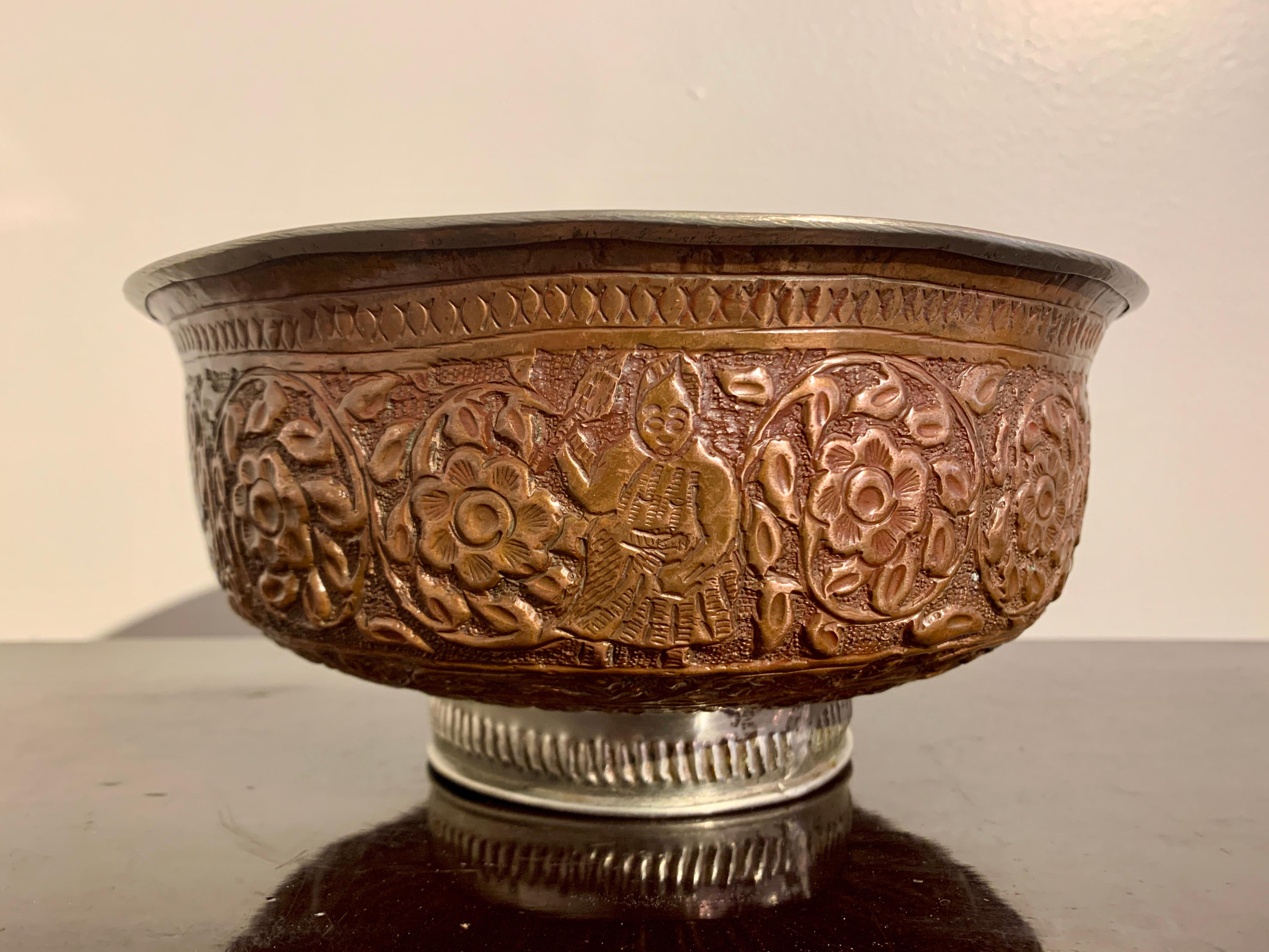 A large and boldly decorated Kashmiri repousse copper bowl, early 20th century, Kashmir.

Set upon a short pedestal foot, the copper bowl features high walls and a slightly everted rim. The body of the bowl is decorated in wonderful raised