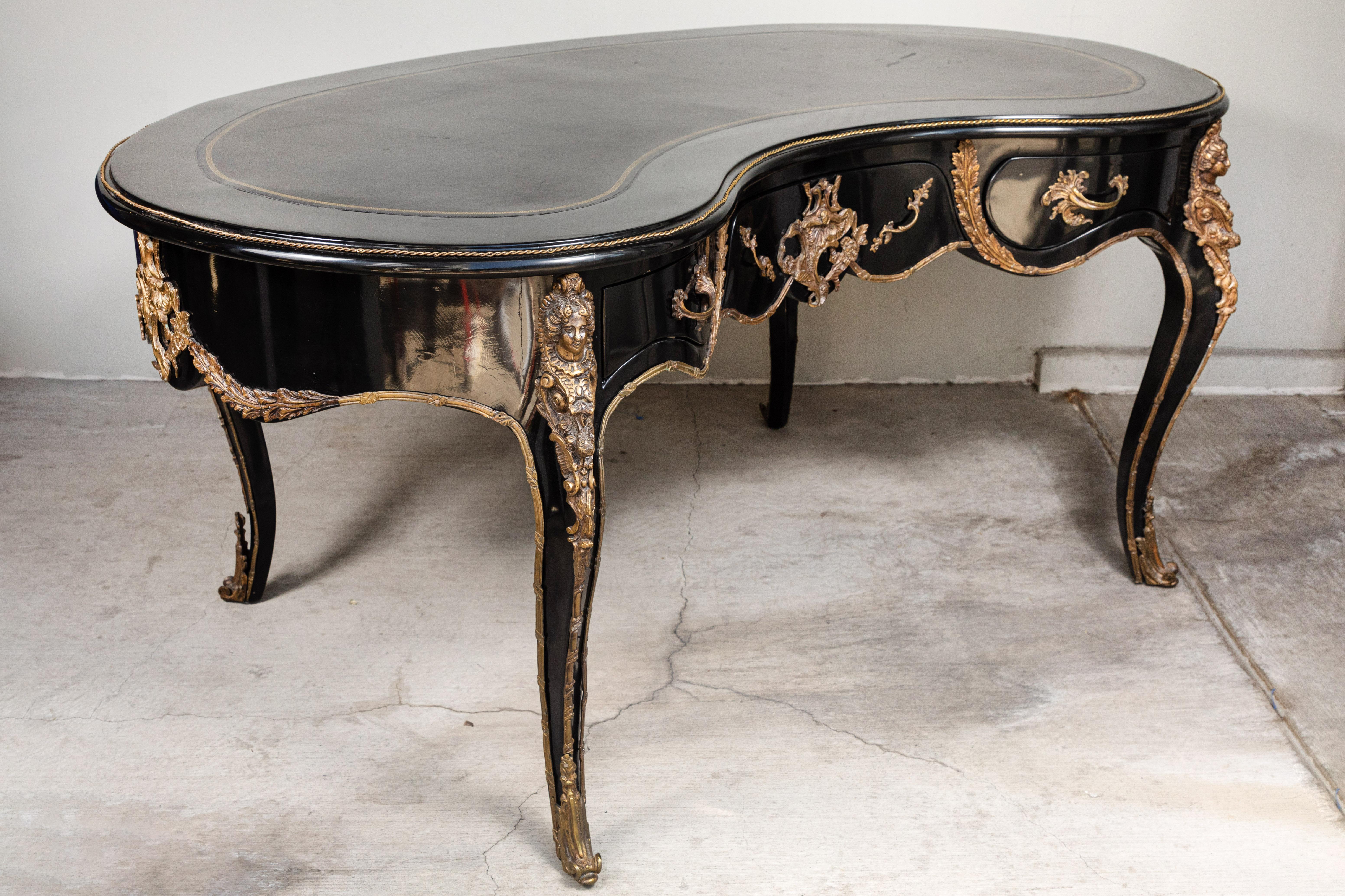 Monumentally sized French desk, late 19th century, kidney shaped, in black lacquer, with bronze ormolu trim and an inset black leather top with gold detailing The size of this desk is unusually large for a French desk of this period and would mix