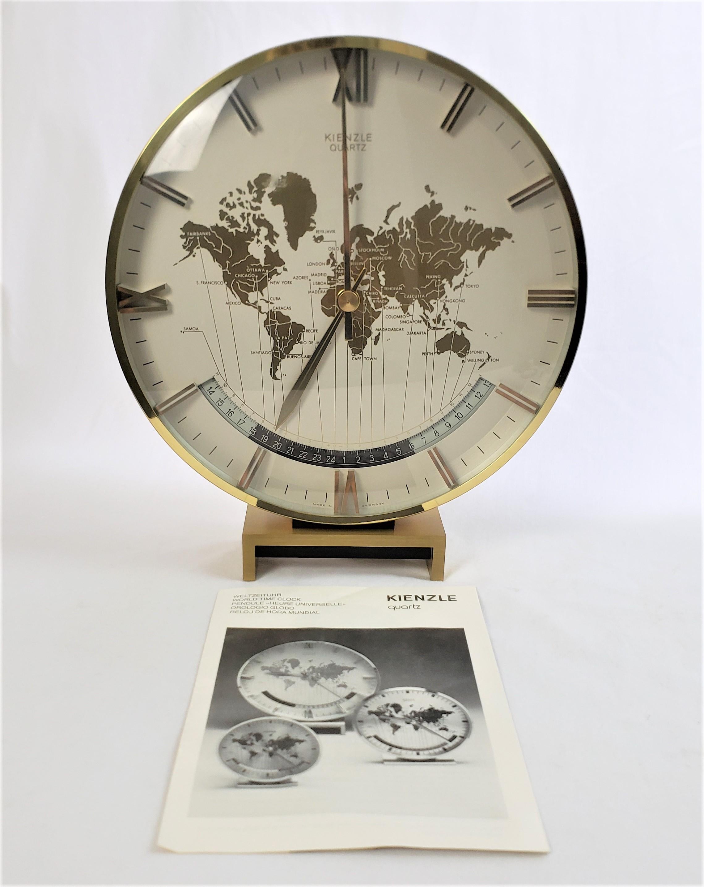 This large table or desk clock was made by the well known Kienzle clock company of Germany and dates to approximately 1970 and done in a Mid Century Modern style. The clock case is composed of heavy polished brass which accents the World map on the