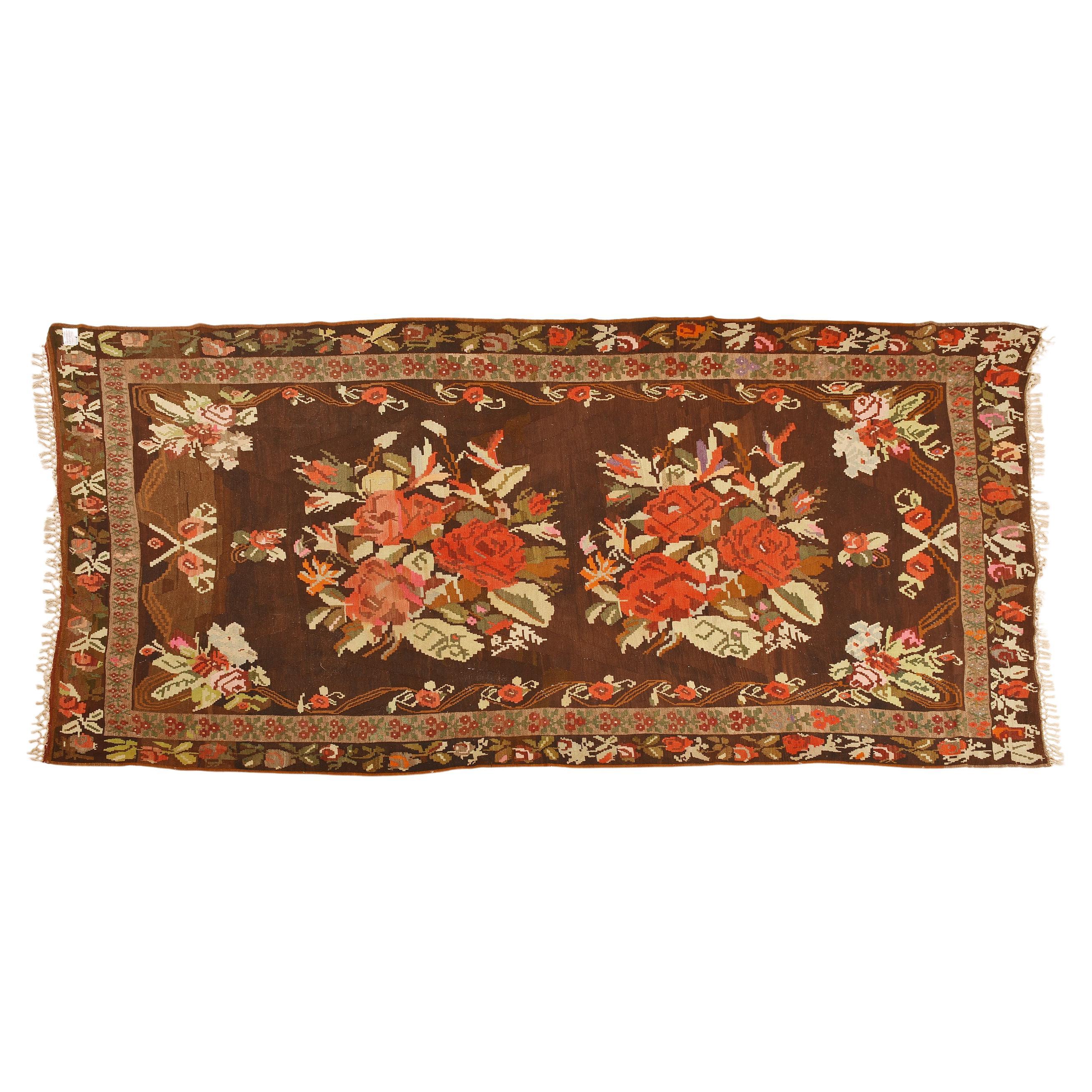 nr. 374 -  On a brown background a beautiful floral design, with different shades of red, pink and green.  The first were the kilims that Russian nobles had weavers from the Caucasus weave, copying the Aubusson carpets they saw at the tsar's