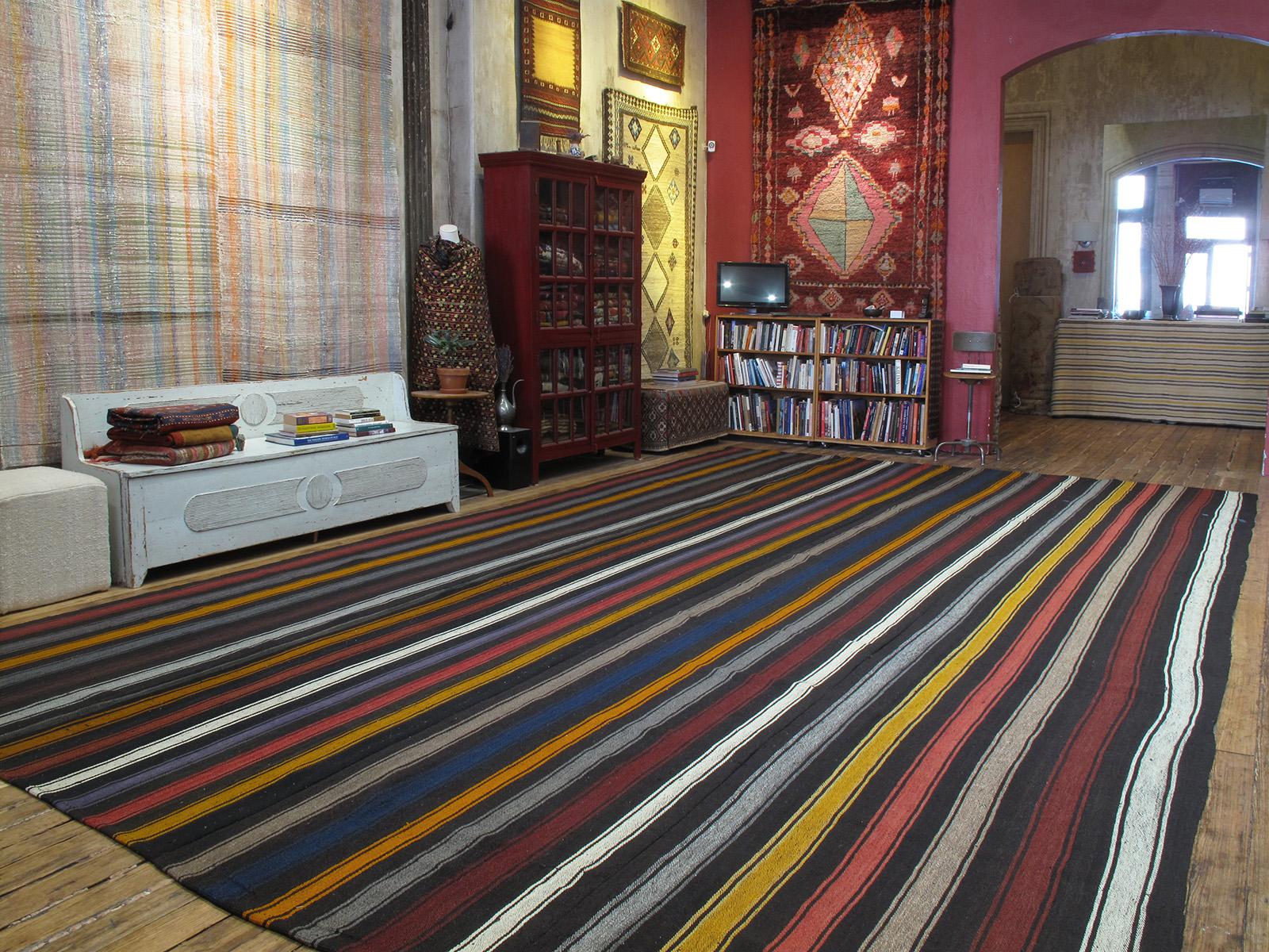 A very large tribal flat-weave from Southeastern Turkey, woven with wool and goat hair in multicolored vertical bands. A kilim like this would have been used as a utilitarian, everyday floor cover in the weaver's household. Despite its humble