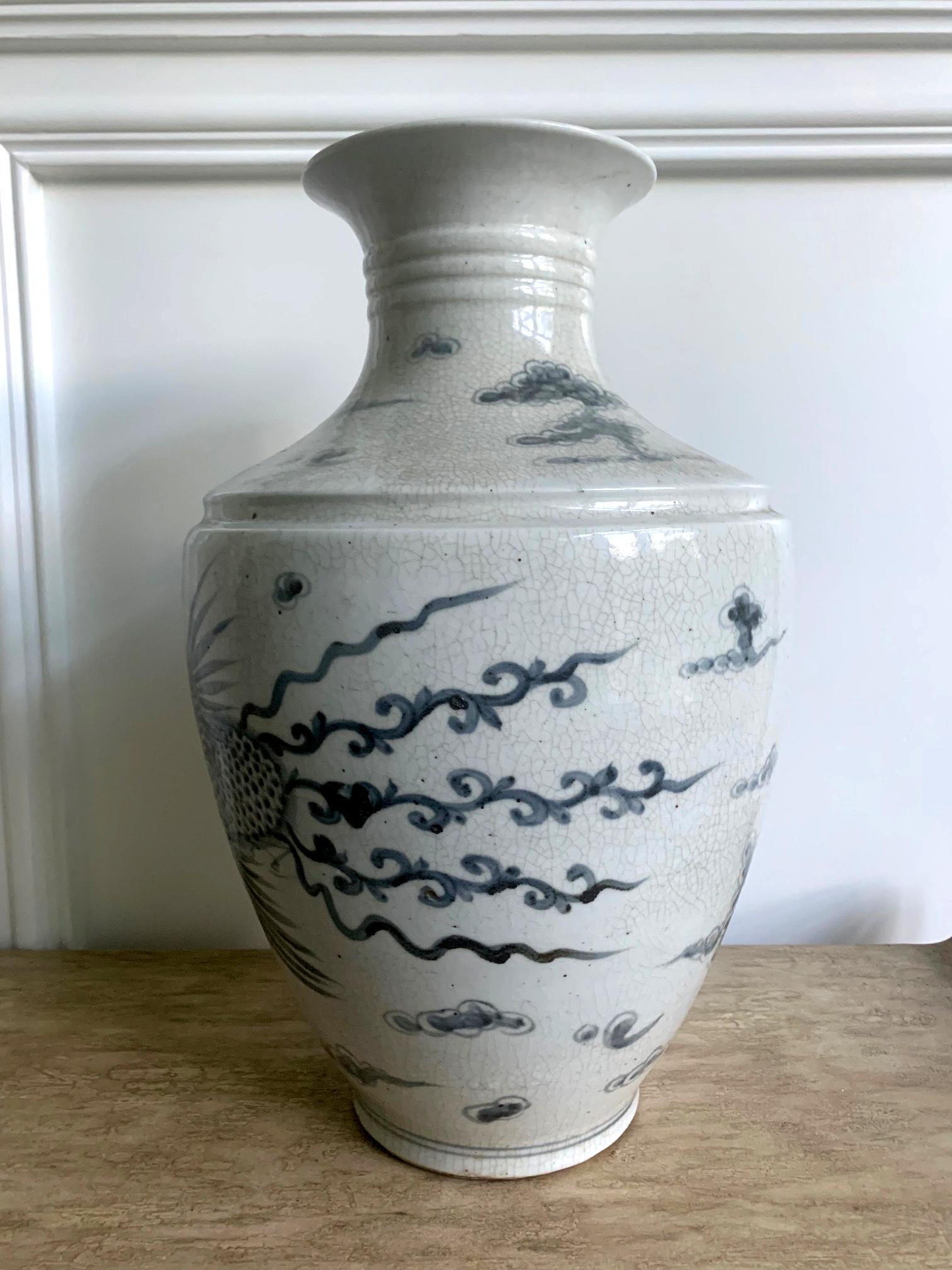 Eine große und schwere koreanische Keramikvase in klassisch chinesischer Form mit offener Mündung mit weit ausgestelltem Rand, einem Hals mit drei konzentrischen Rillen und einer schrägen breiten Schulter. Das blau-weiße Design zeigt zwei