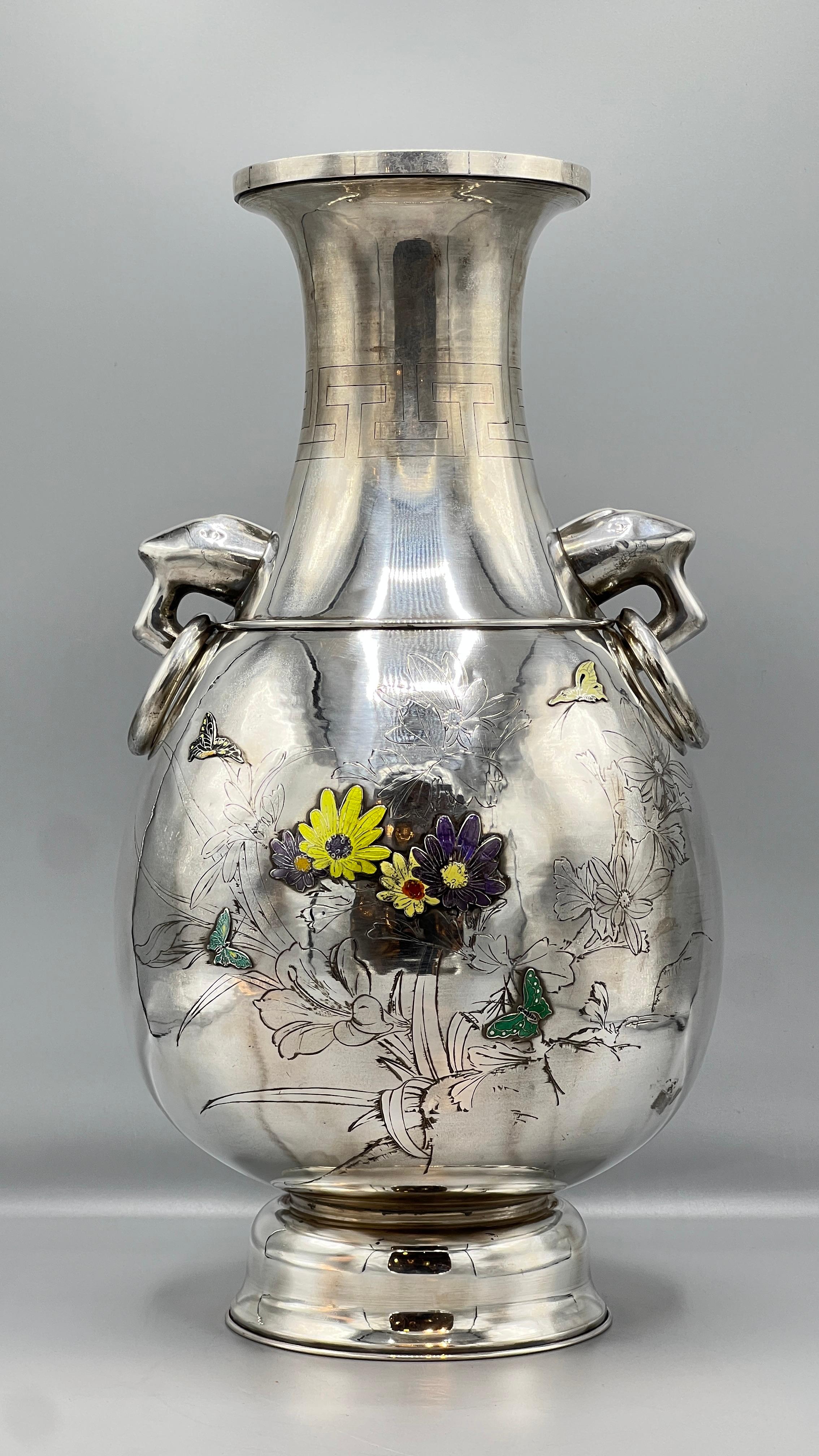 Large vintage 20th century Korean vase in pure silver floral designs in pale violet/blue and yellow and elephant handles with rings.  Marked SILVER and 
Sun Eun (pure silver).  We have not found a maker's mark.
