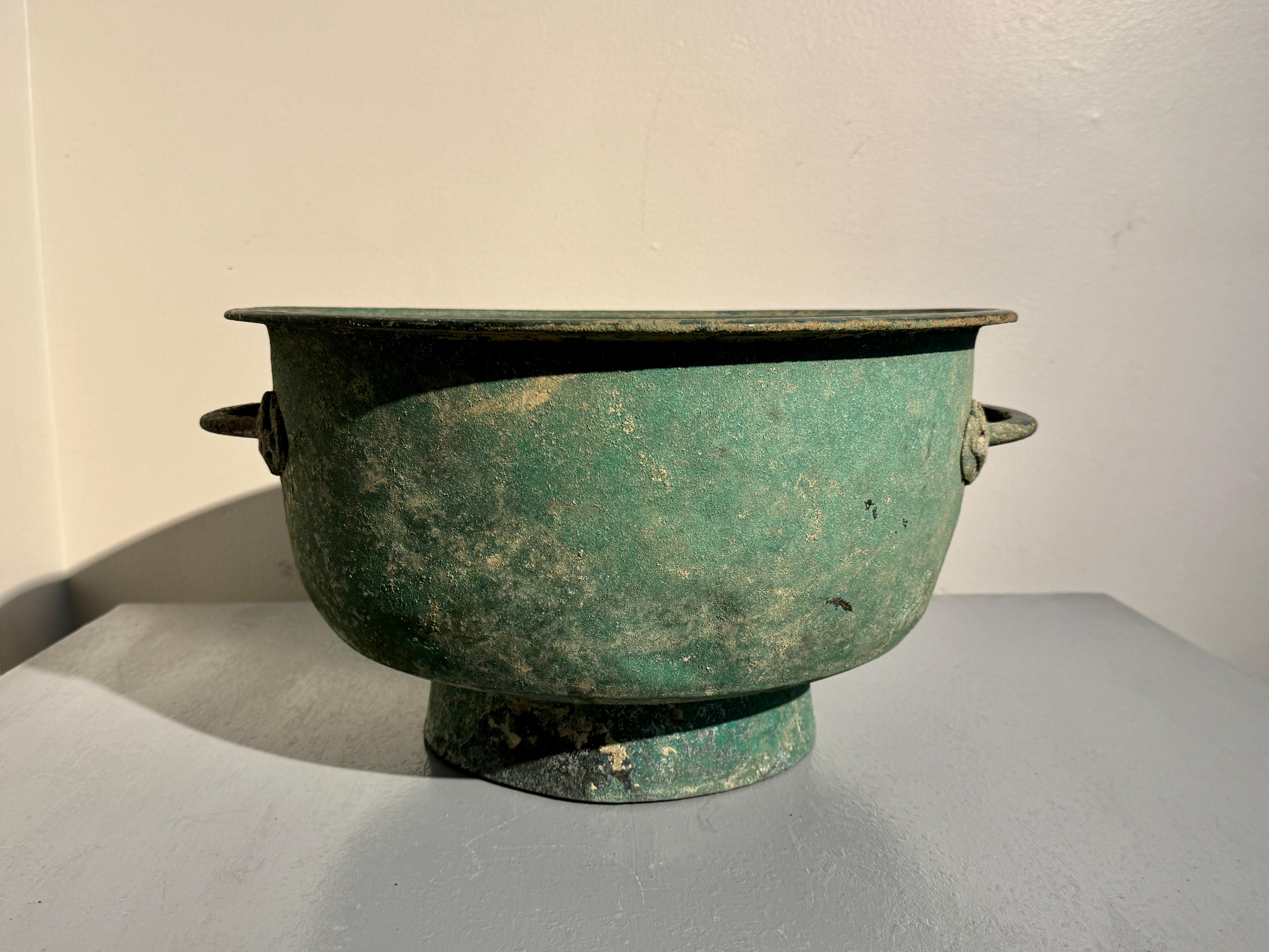 An unusually large and impressive Korean Goryeo bronze circular basin with applied handles and stunning patina, Goryeo Dynasty (918 to 1392), 12th - 14th century, Korea. 

The large basin of typical circular form, set on a high, slightly splayed,