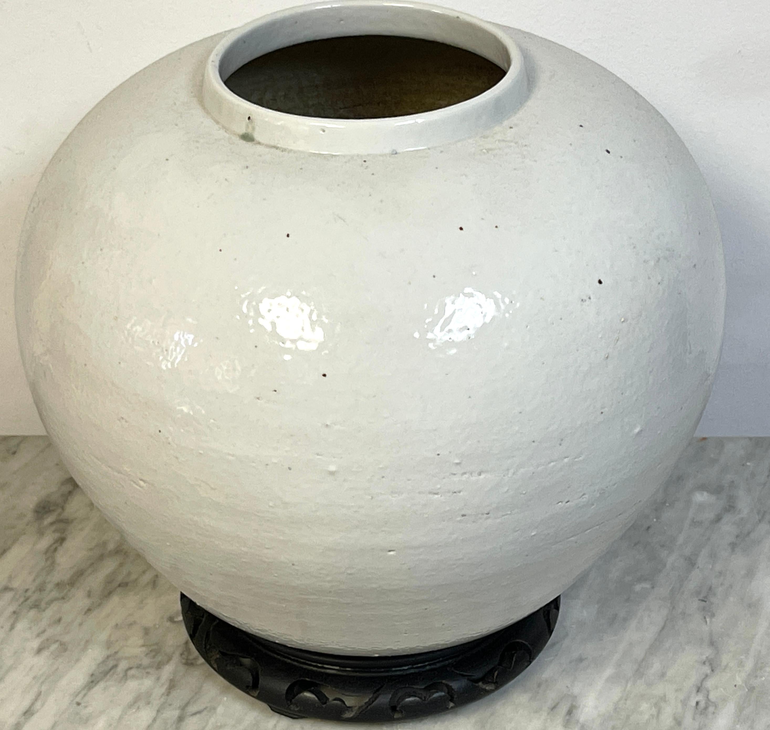 Large Korean Monochrome Porcelain Moon Jar on Carved Wood Stand, 20th Century Coreano en venta