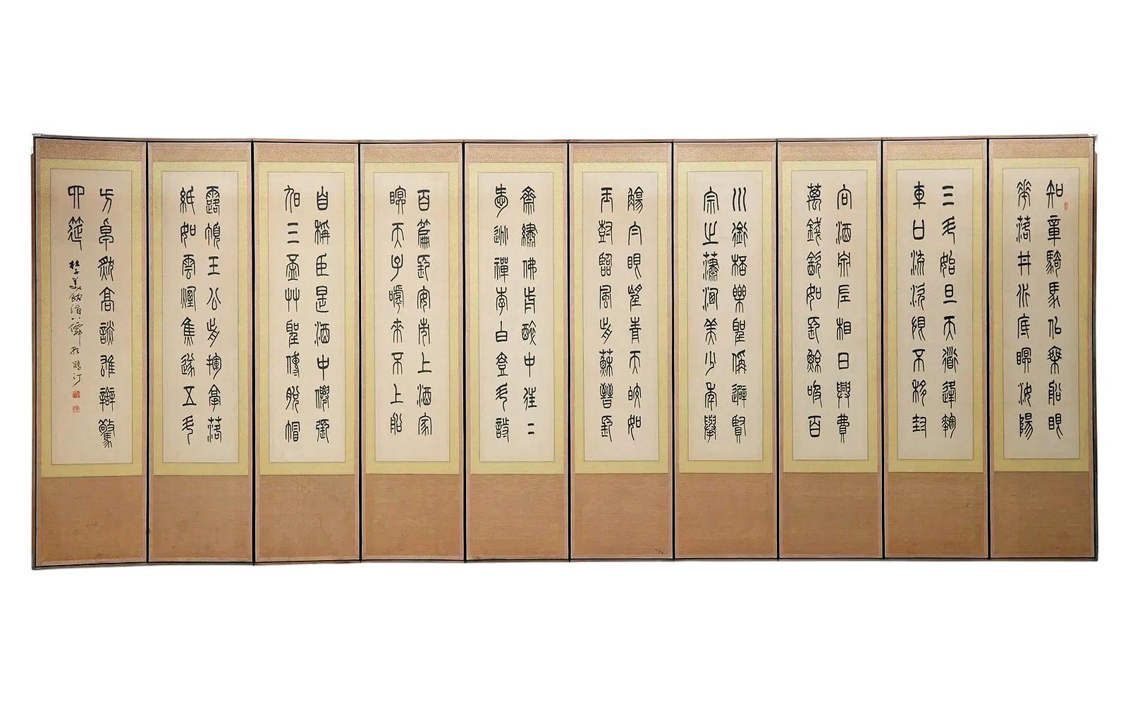 A large and striking ten-fold Korean floor screen of ink calligraphy in ancient Chinese seal script, beautifully matted with two color-way golden silk border, light wood frame and white copper corner hardware. 
The calligraphy is a poem entitled