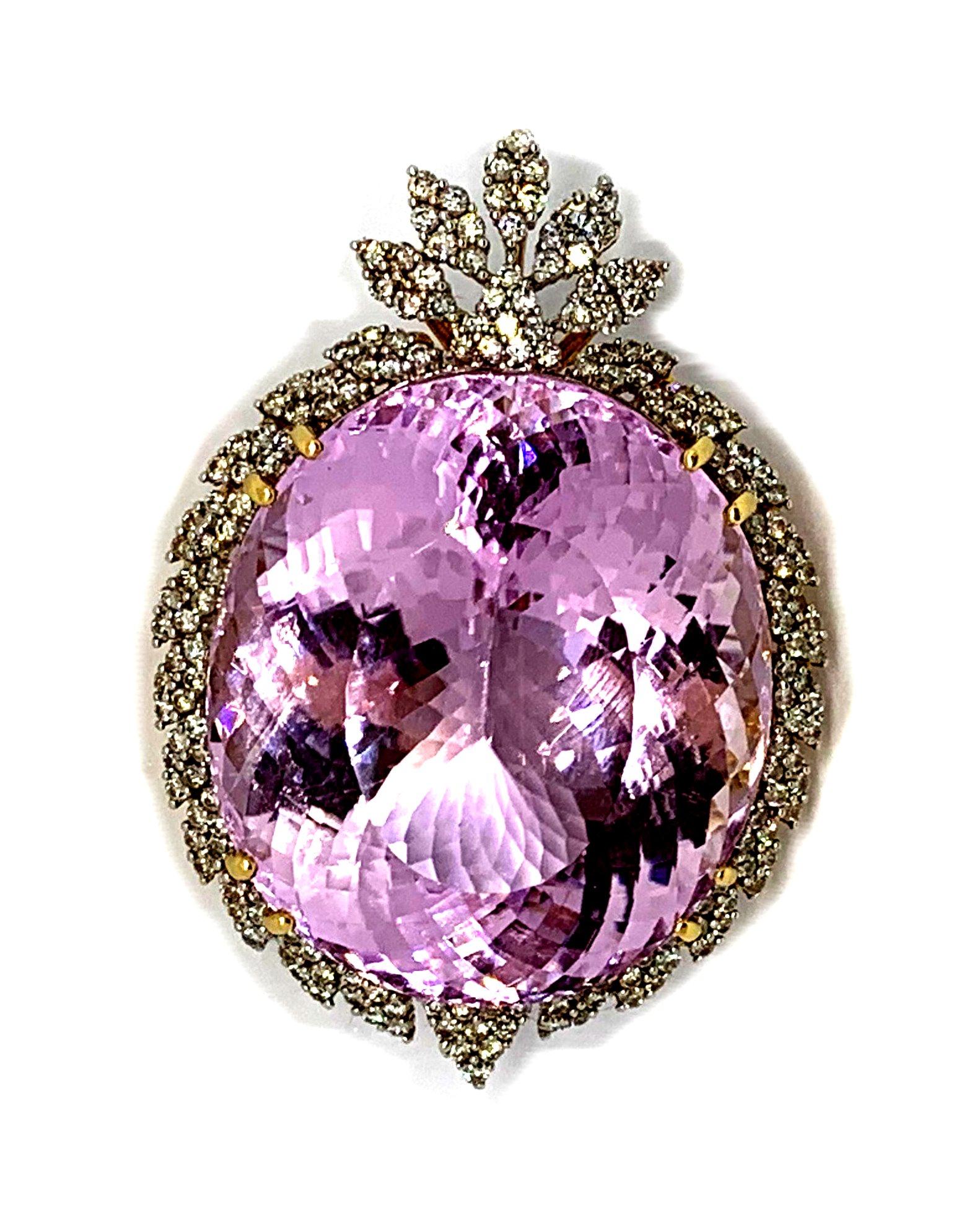 A statement re carpet piece.
PENDANT, an oval faceted pink kunzite/spodumene, secured in a claw setting within a
surround of diamond set leaves and surmounted by a spray of diamond set leaves.
The kunzite measures 33mm x 28.7mm, depth 17.62mm (ca