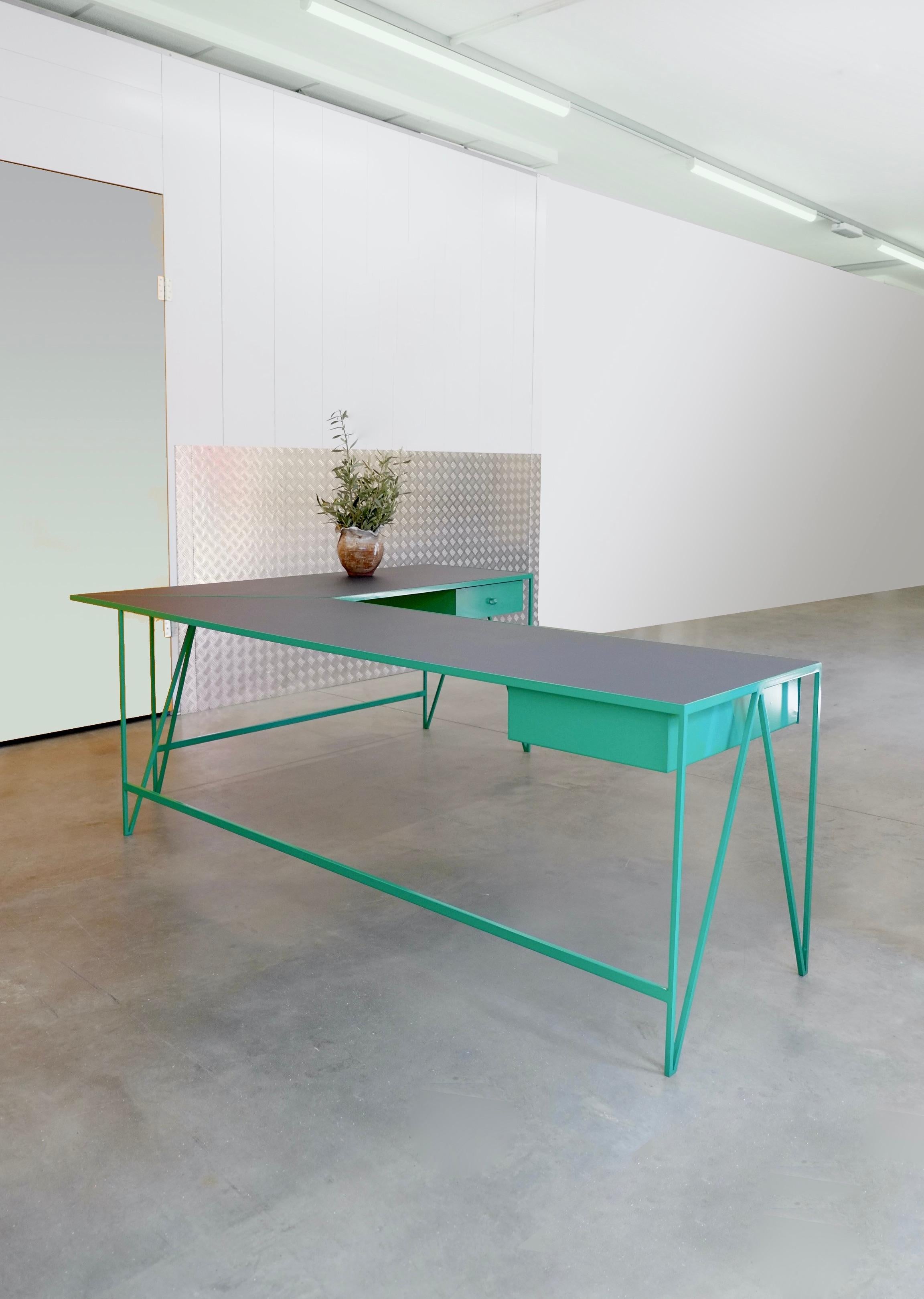 A beautiful large L Shaped Study desk made with a bright green powder-coated steel frame and a charcoal linoleum top made from all-natural ingredients, such as flax, wood flour, and limestone. The furniture linoleum provides a natural satin matt